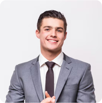 A smiling young man in a gray suit and black tie posing against a plain white background.