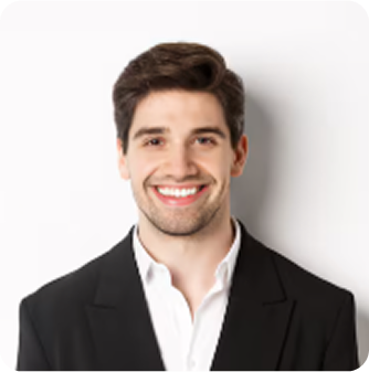 A smiling young man with dark hair, wearing a black suit and white shirt, standing against a white background.