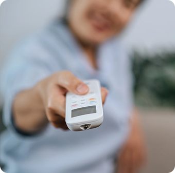 Person holding a remote control, pointing it towards the camera.