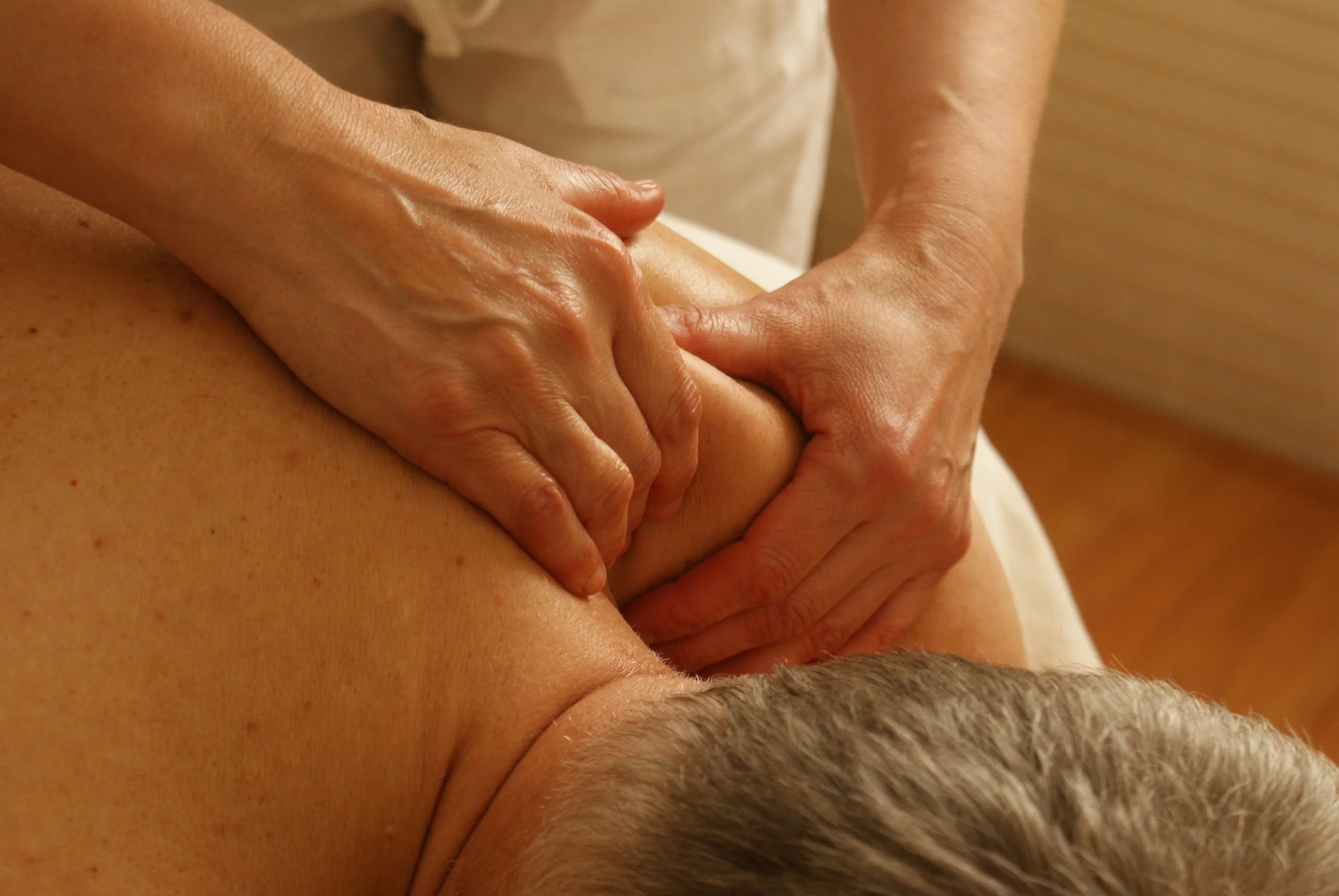 Person receiving a massage on their shoulder and upper arm.