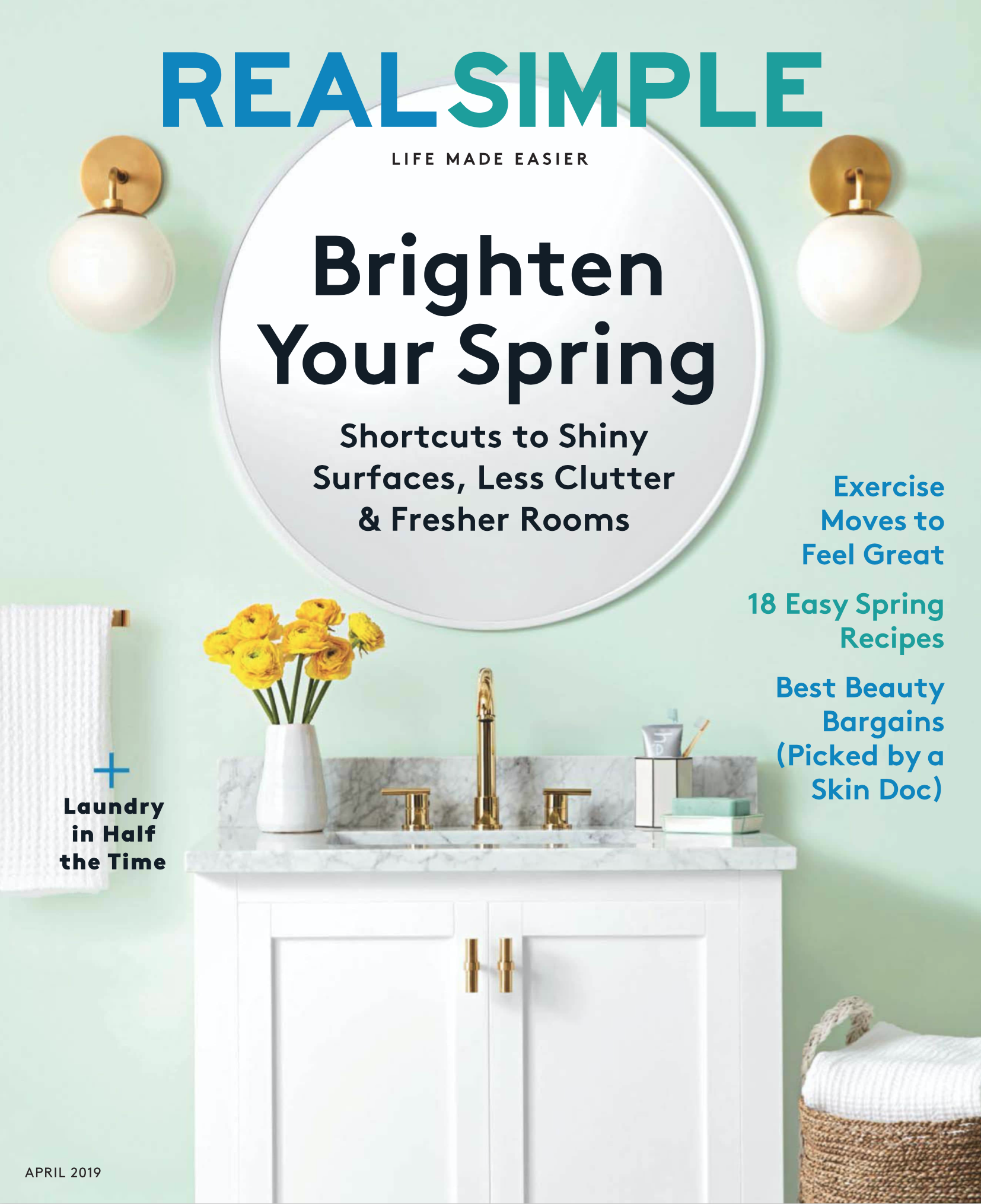 The cover of a spring home improvement magazine featuring a bathroom with a white vanity, gold fixtures, a vase of yellow flowers, wall sconces, and light mint green walls. The headline reads 'Brighten Your Spring' with subheadings about spring cleaning tips and recipes.