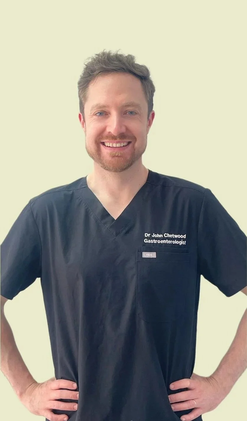 Gastroenterologist in North Sydney. His scrubs have a name tag that reads 'Dr. John Chetwood Gastroenterologist.'