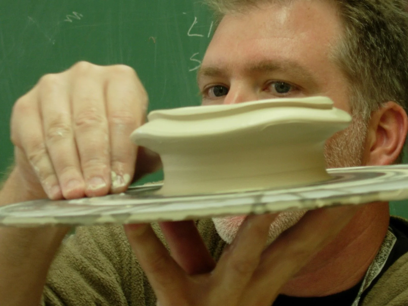 Conner Burns, clay artist, demonstrates a wheel thrown form.