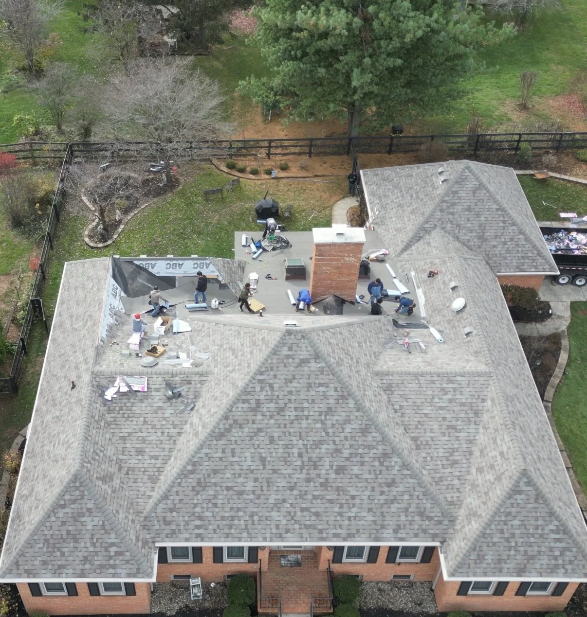 Roofing crew installing new shingles on residential home in Lexington KY during roof replacement project