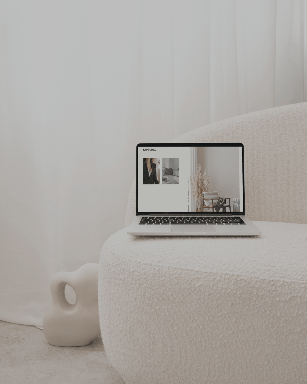 Website mock up with macbook sitting on top of a white lounge