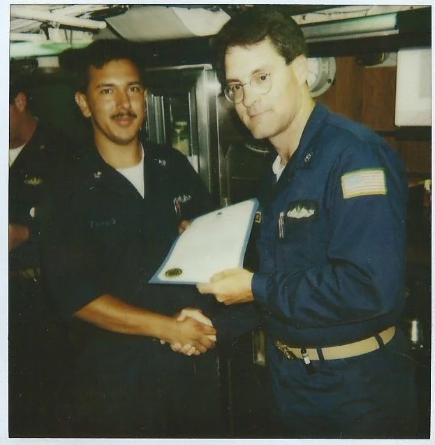 Jeremy James, U.S. Navy sailor, receiving an award from the commanding officer aboard a submarine.