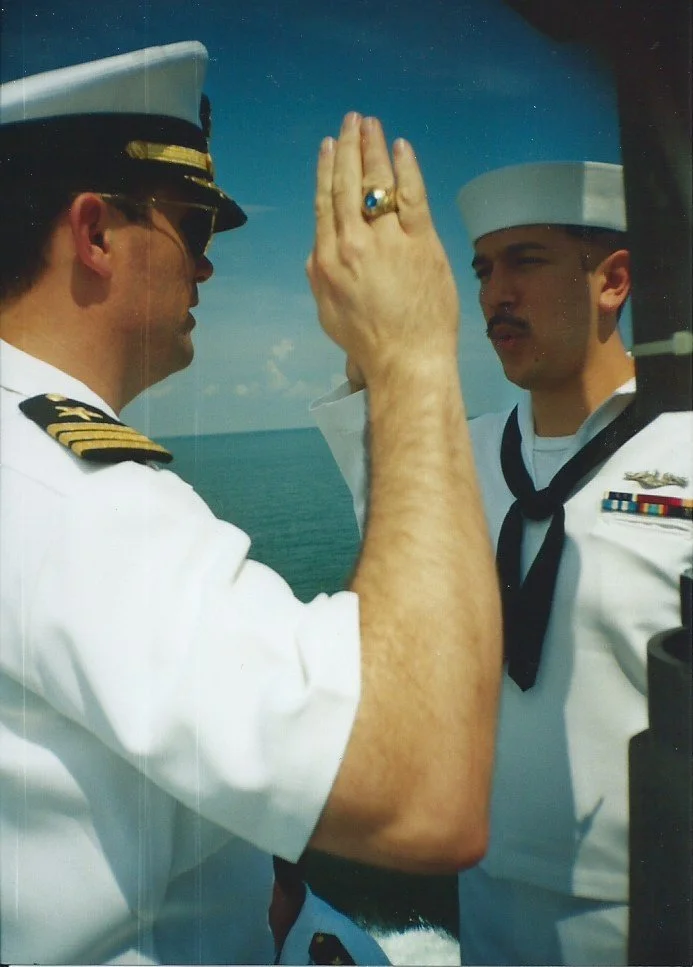 A Navy officer swearing in a young sailor, Jeremy James, with a sea and sky background