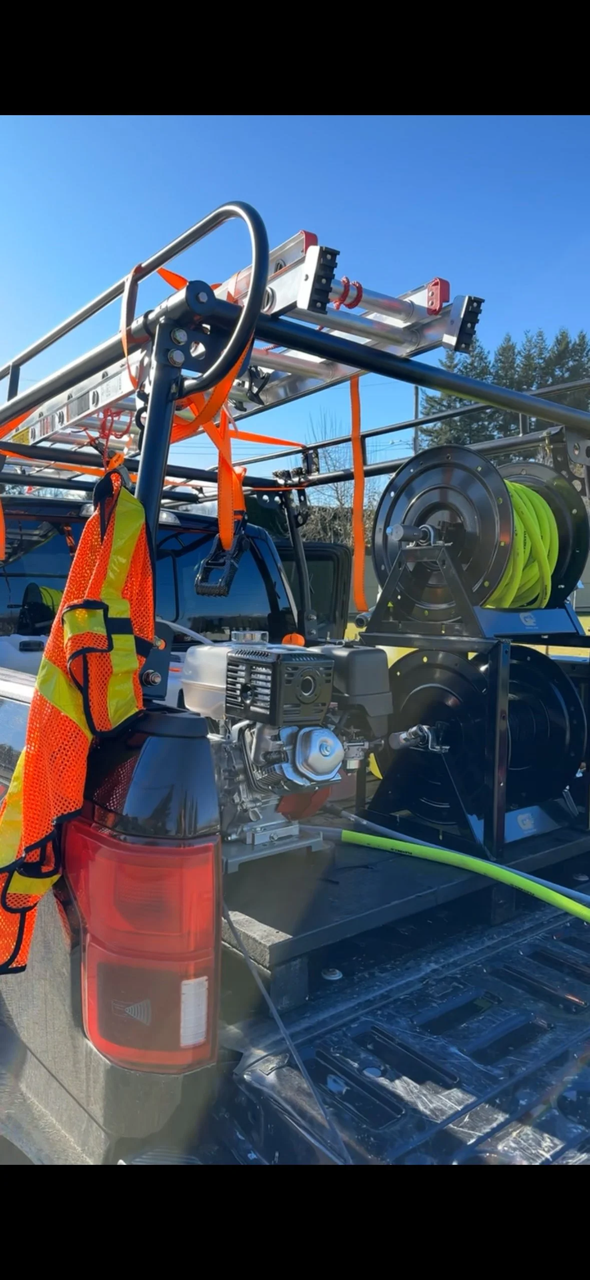 Fire truck equipment including a ladder, hoses, and safety gear mounted on the back of a pickup truck.