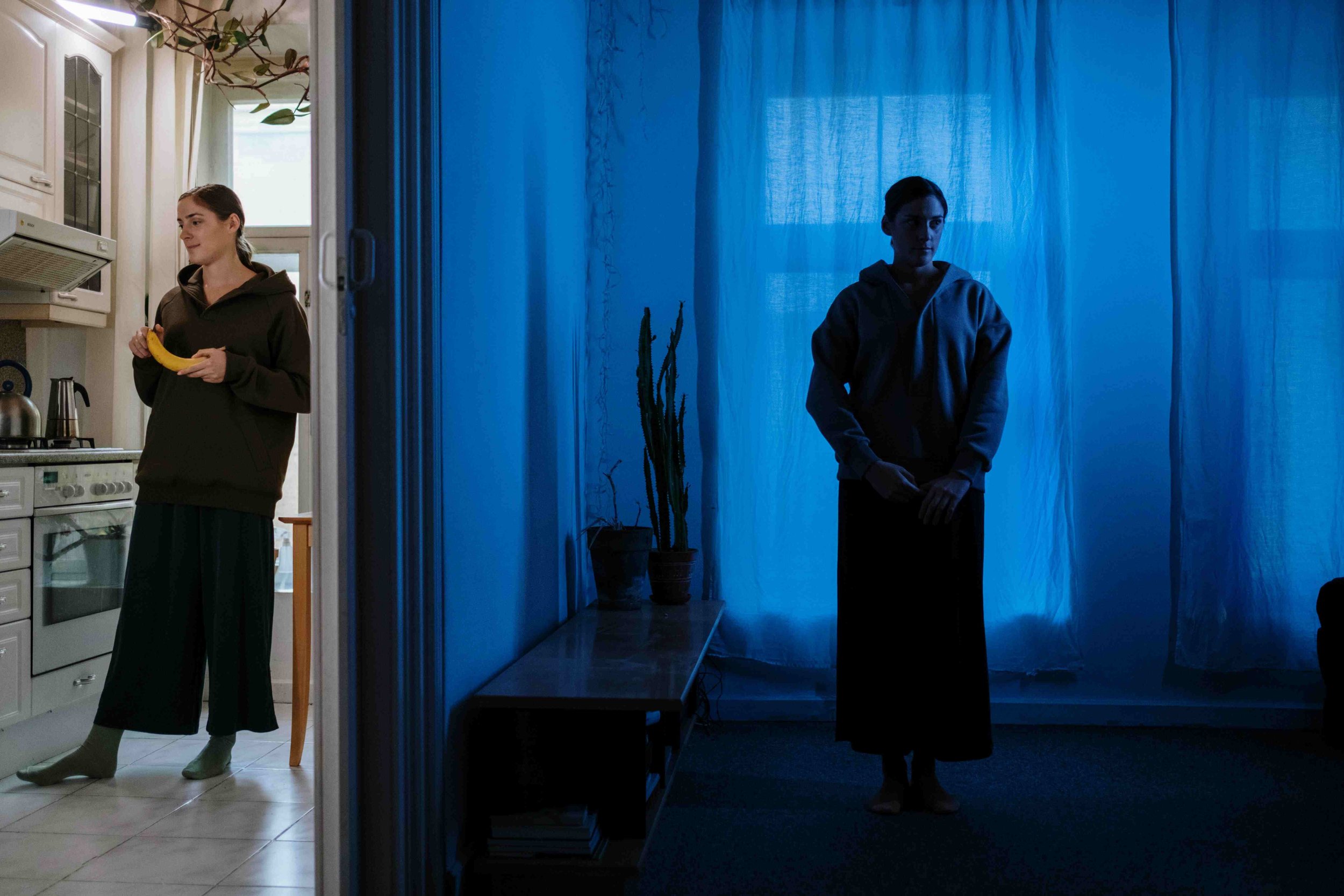 A split view of a woman in a kitchen holding a banana on the left, and a woman standing in a dark room with blue lighting on the right.