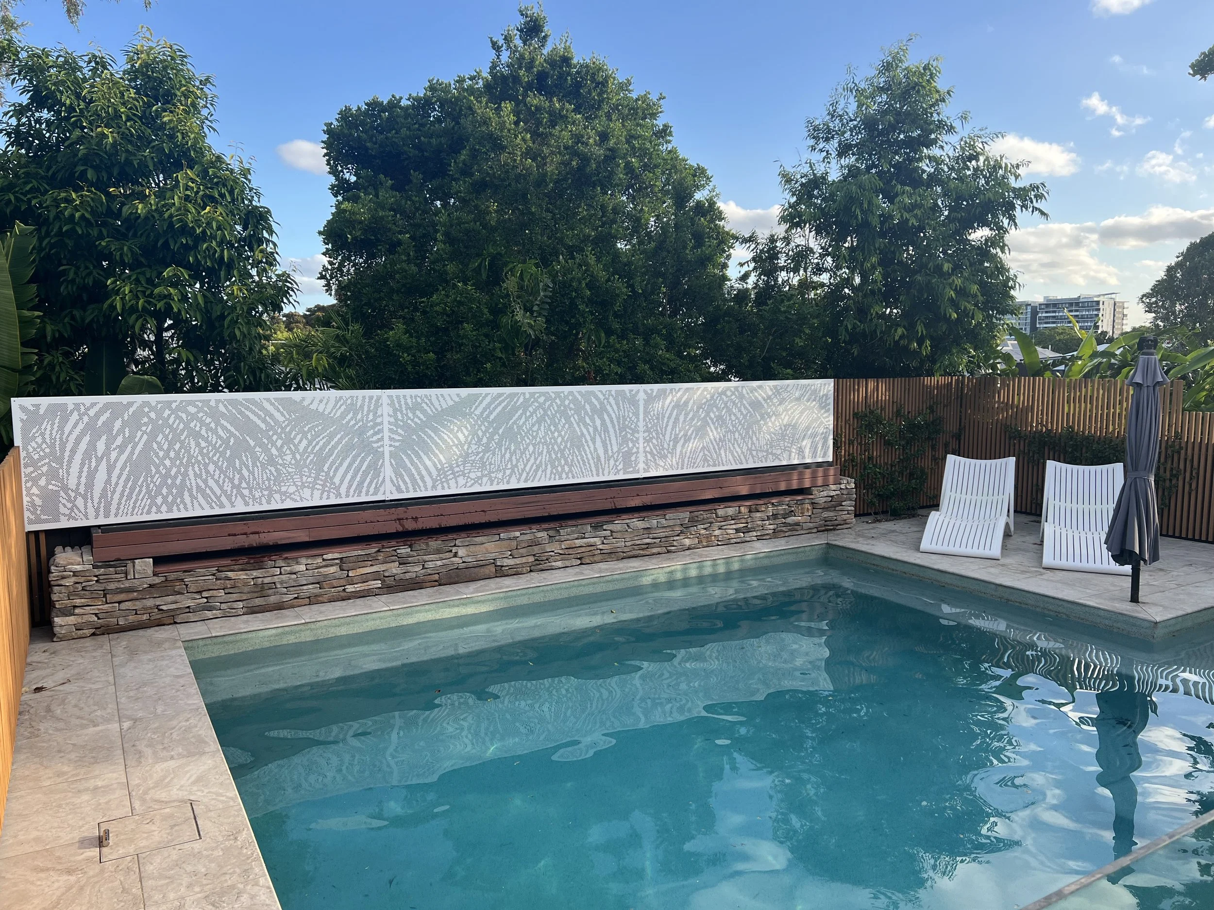 Perforated privacy screens for pool area. Urban metal custom design in palm leaves pattern. Designed specifically to suit client specifications