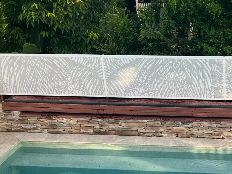 custom designed perforated privacy screening for pool area. non-climbable. custom palm leaves design