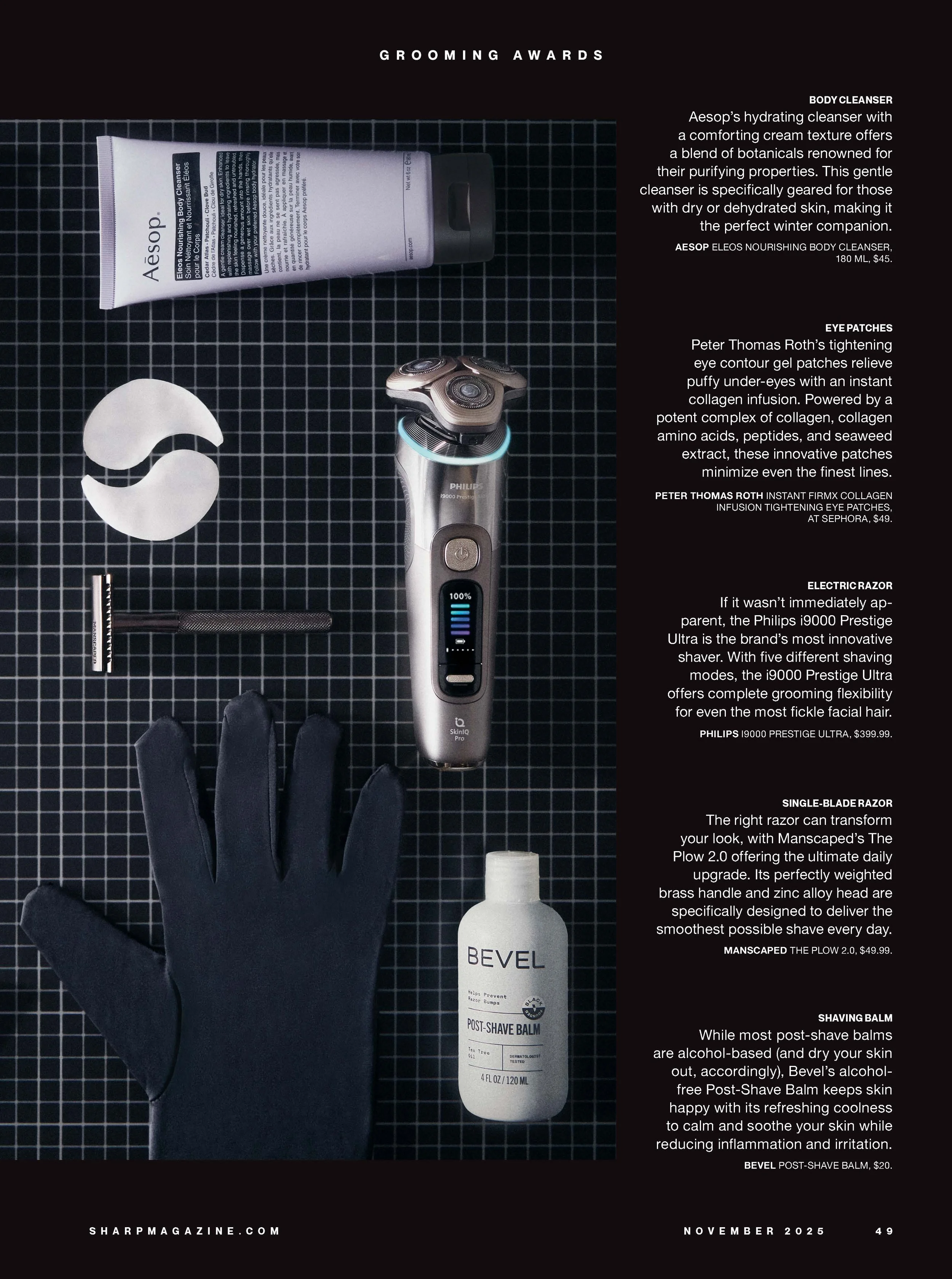 A flat lay of grooming products including a tube of Aesop body cleanser, a pair of eye patches, a Philips electric shaver, a black glove, a razor with a black handle, and a bottle of Bevel post-shave balm, arranged on a black grid background.