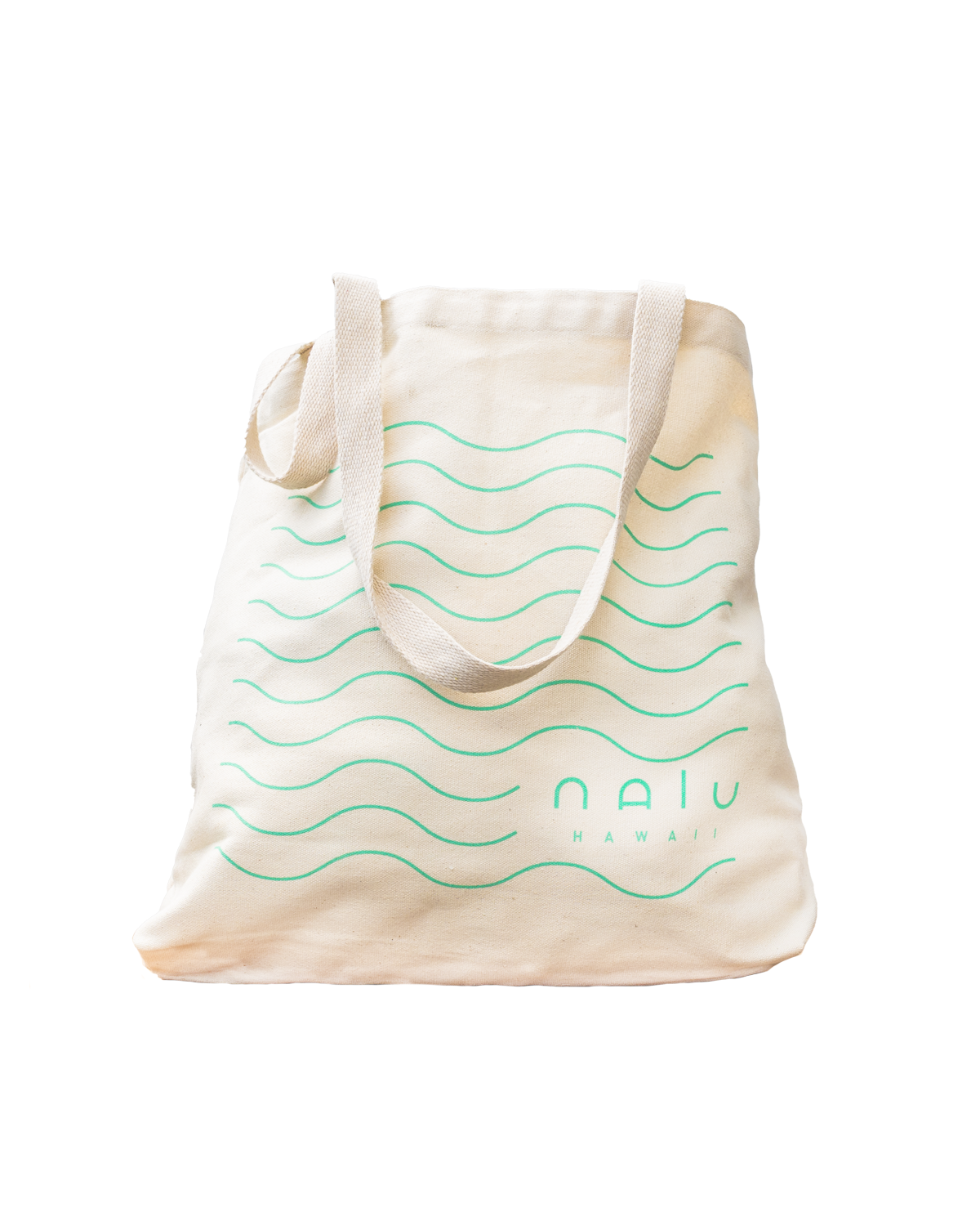 A beige tote bag with green wave patterns and the words 'Naia Hawaii' printed on it.