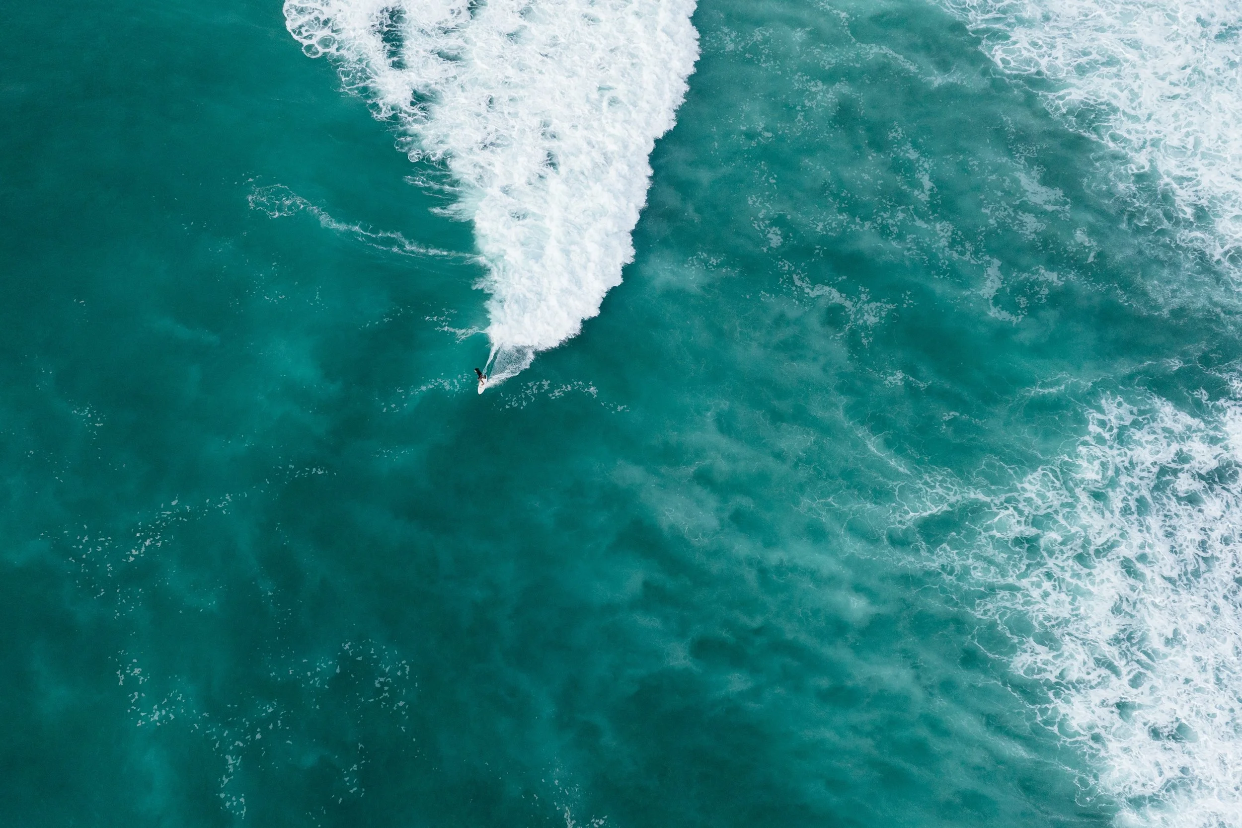 Aerial view of a person surfing on a wave in the ocean
