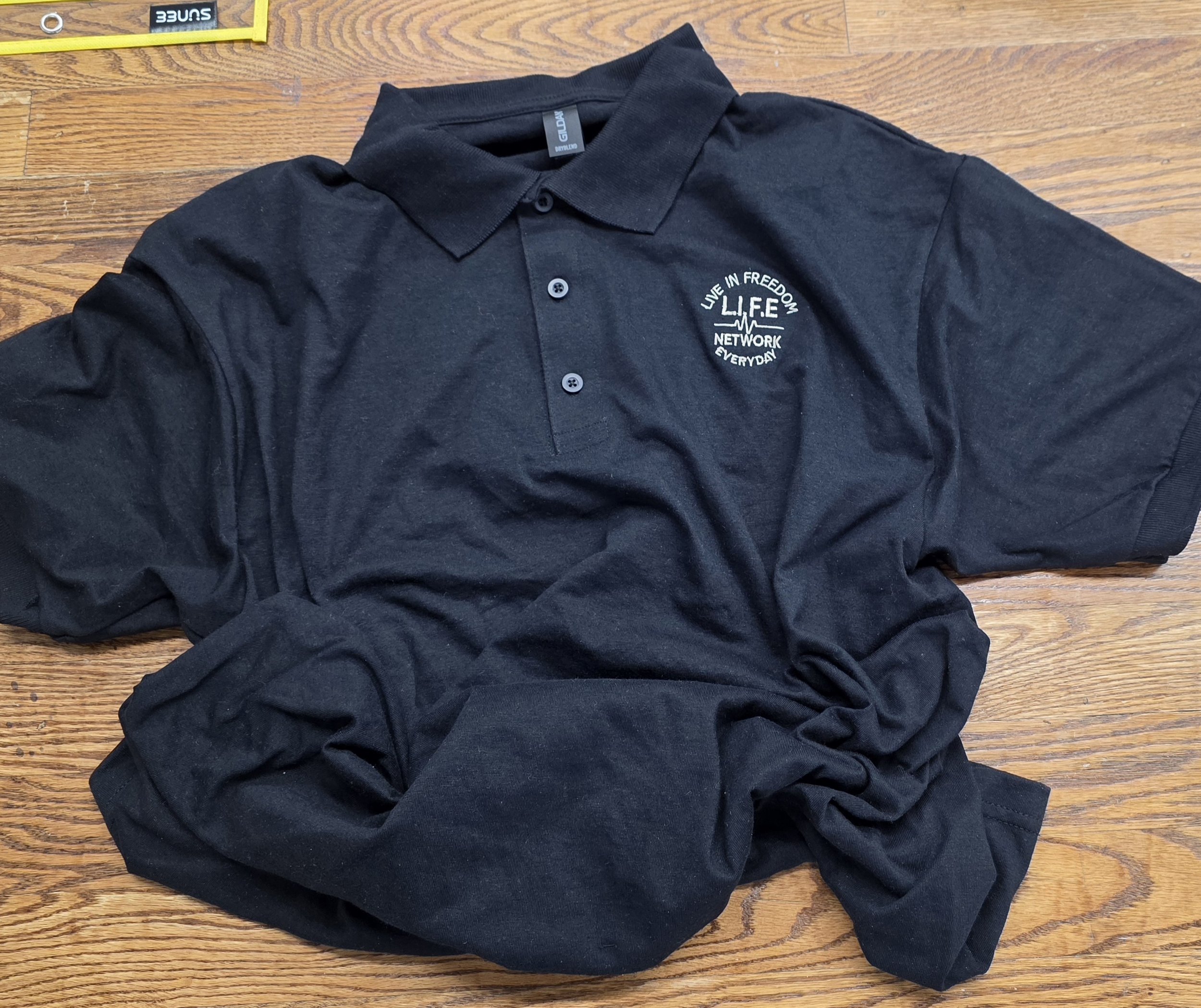 Black Gildan Polo w - cream writting.jpg