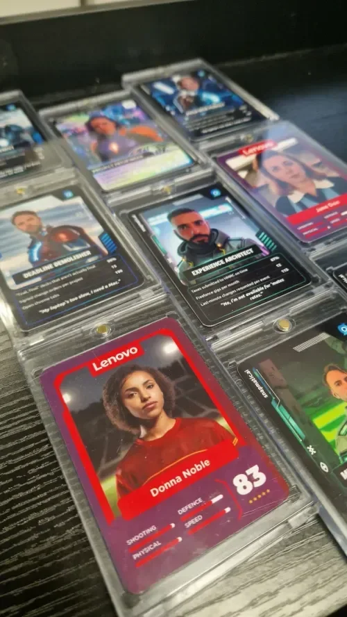 Collection of collectible cards featuring characters with detailed stats in protective plastic cases.