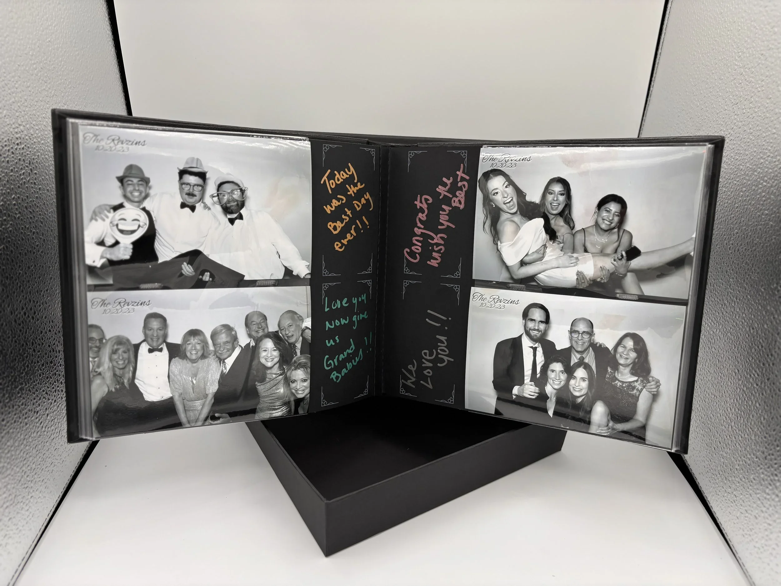 Open photo album showing four black-and-white photos from a wedding, with handwritten notes and messages on the pages.