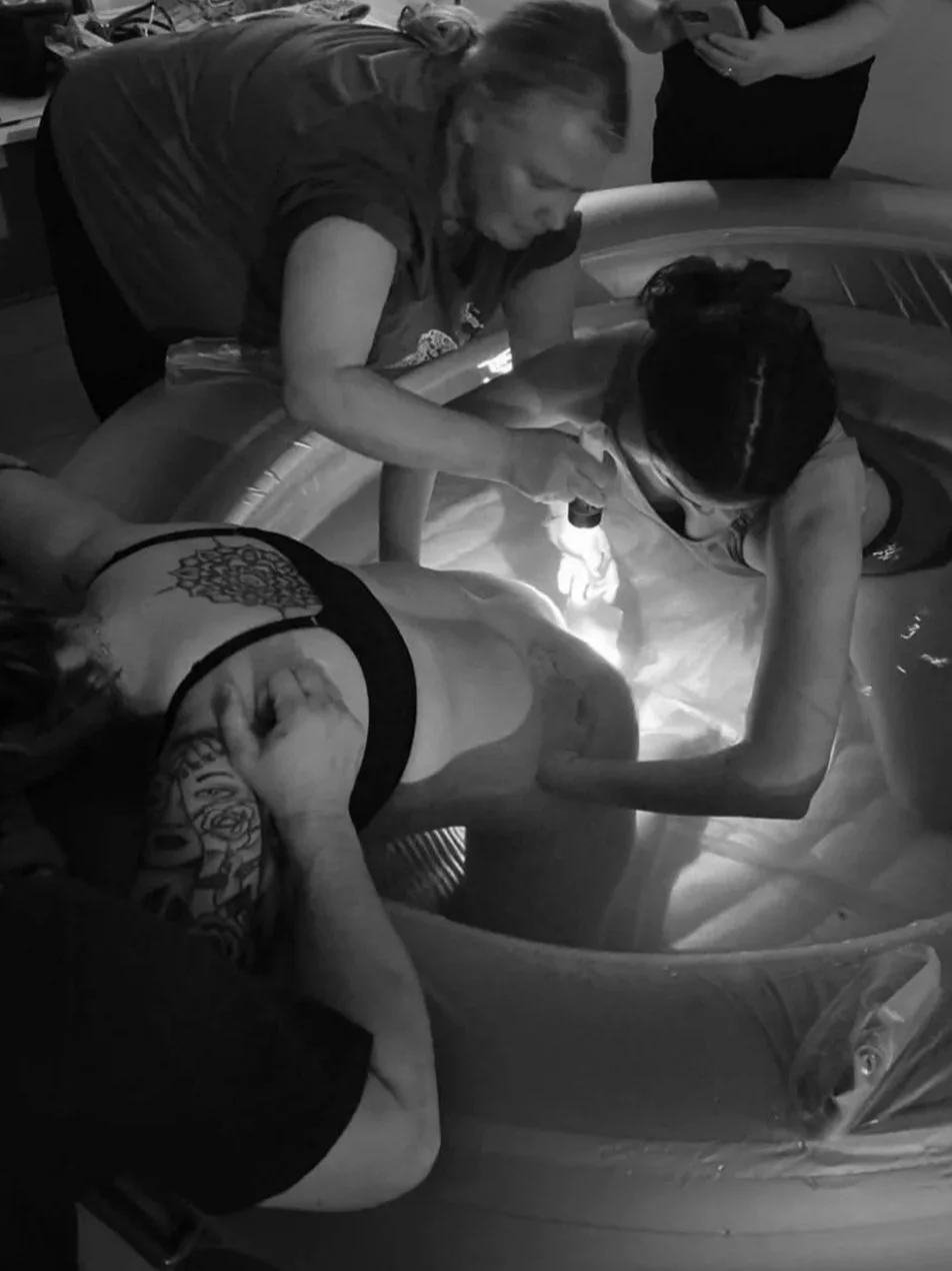 Tattooed woman relaxing in a small inflatable pool.