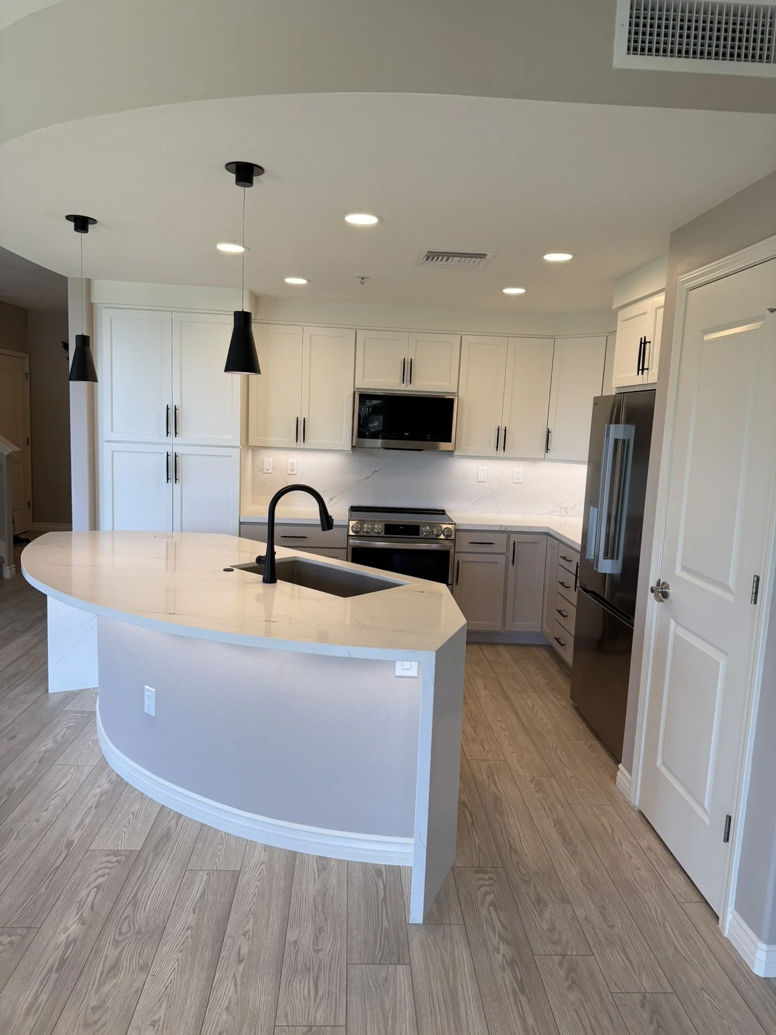 Renovated kitchen with quartz island and white cabinetry at Ke Alii Ocean Villas, Kihei, Maui
