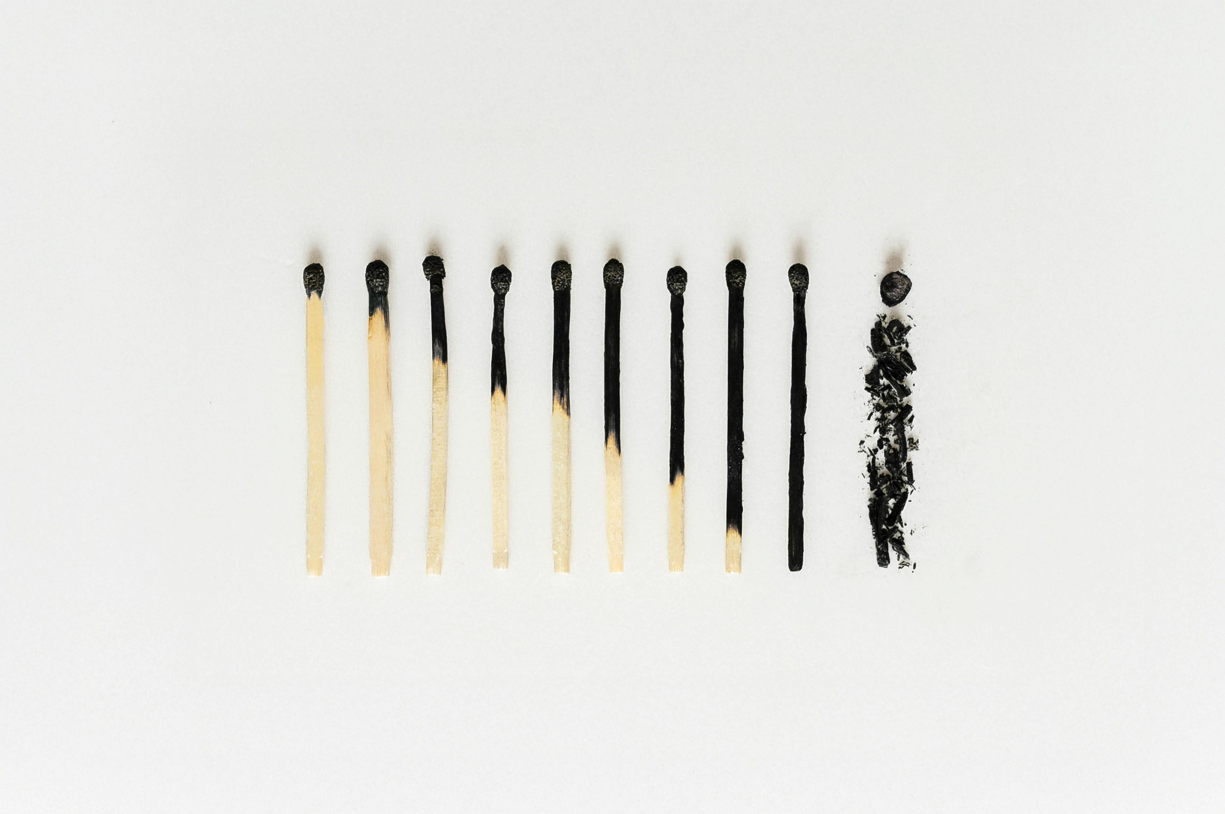 Array of nine matchsticks, with second to eighth matchsticks partially burned, and the last matchstick fully burned down to ashes.
