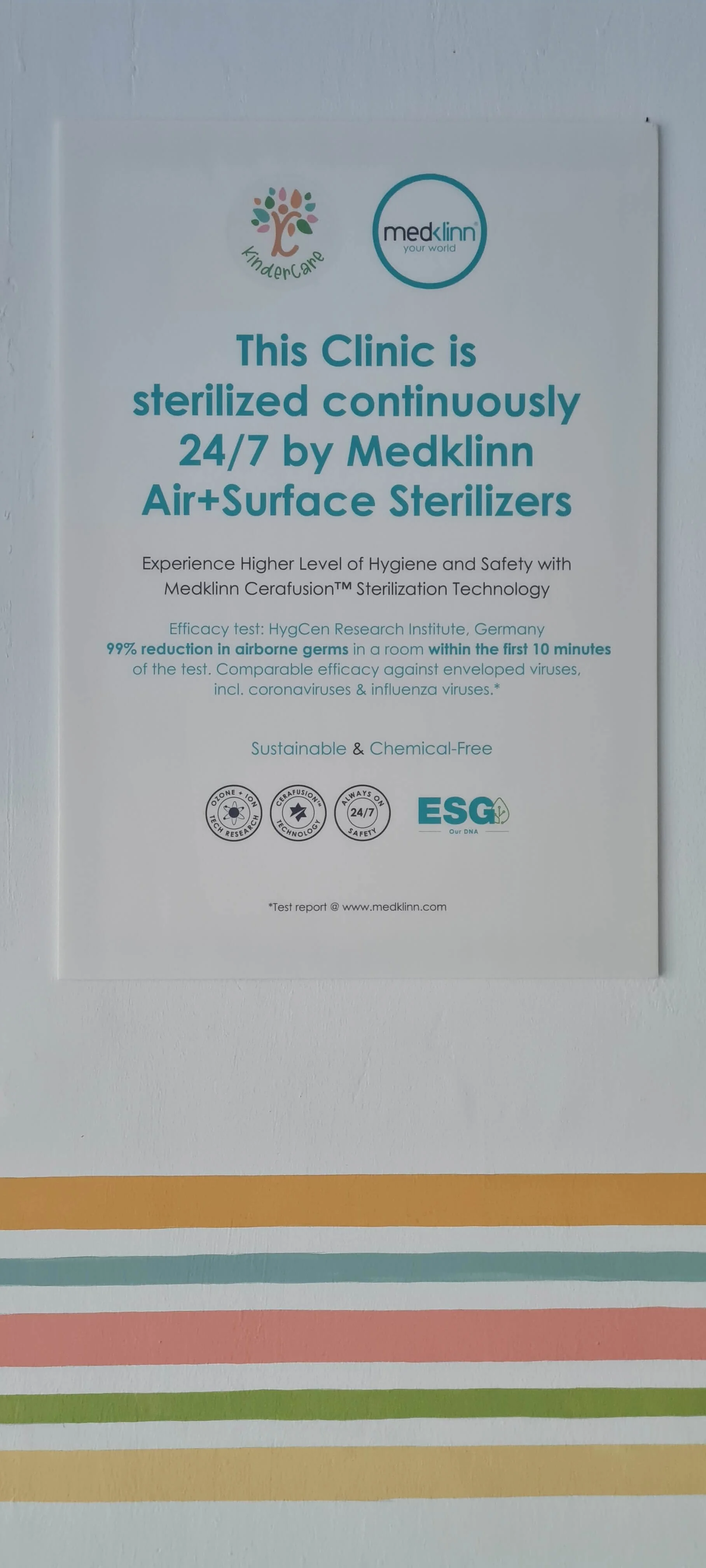 Modern building with wooden facade and large glass window, set against mountainous landscape with dry grass and shrubs in the foreground.