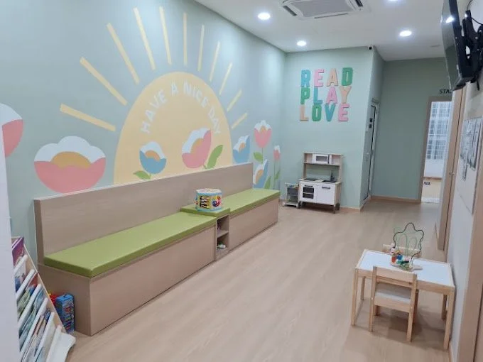 Scenic landscape of a large lake surrounded by green hills and mountains beneath a cloudy sky.