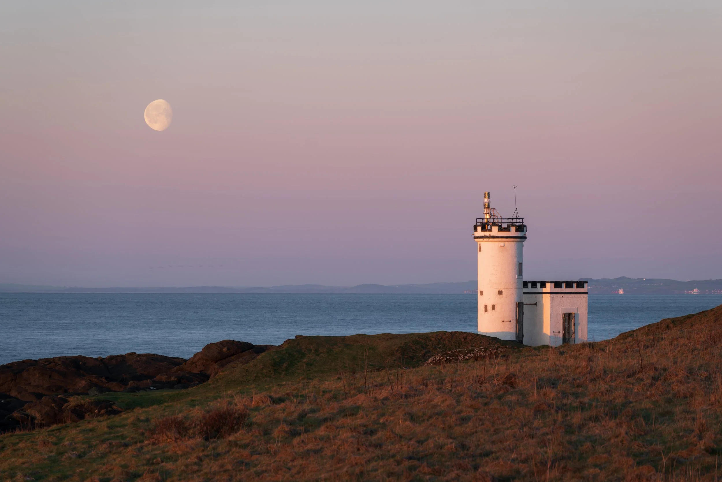 Elie Lighthouse, at sunrise, with the moon in the distance.