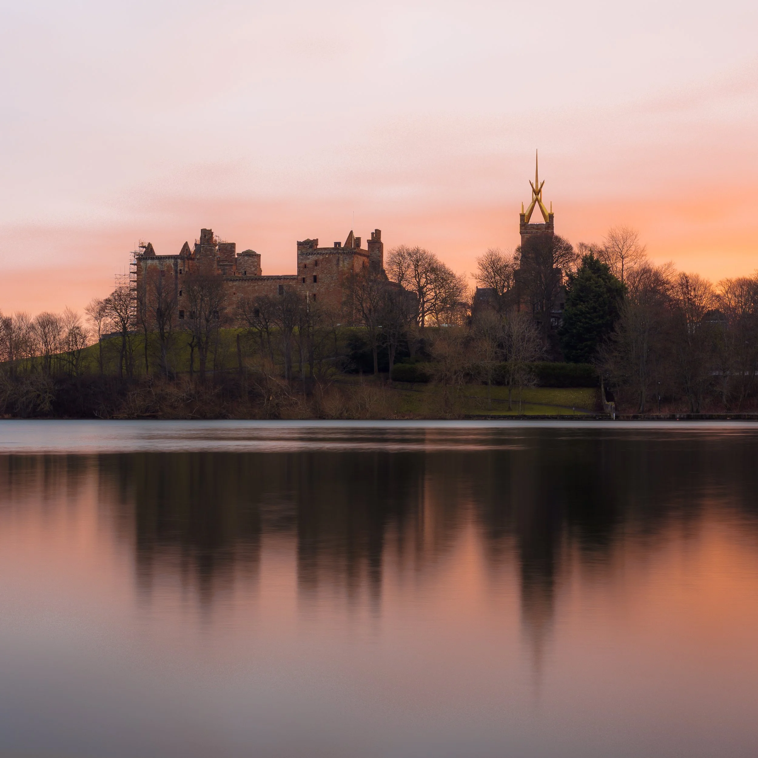 Sunrise colour lights up the sky behind Linlithgow Palace.