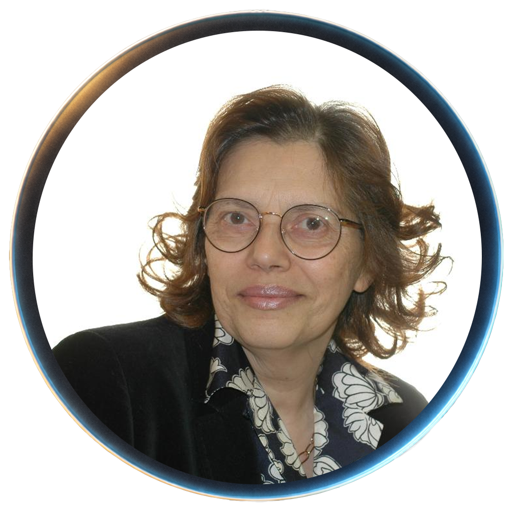 A woman with glasses and shoulder-length curly brown hair, wearing a dark blazer and a floral blouse, looking slightly to her left.