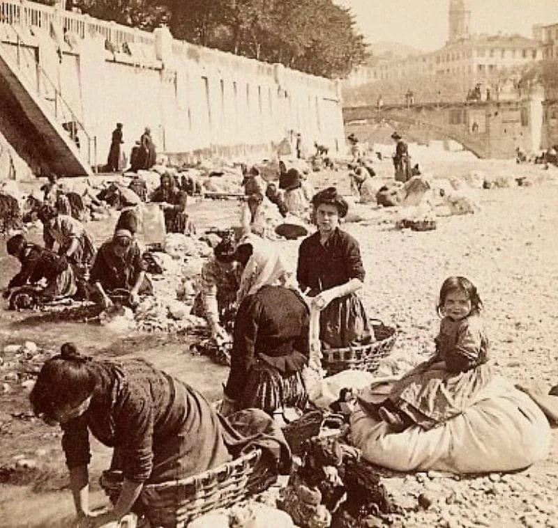 Femme et enfant rassemblés et vendant des produits près d'une rivière, datant probablement d'une époque historique.