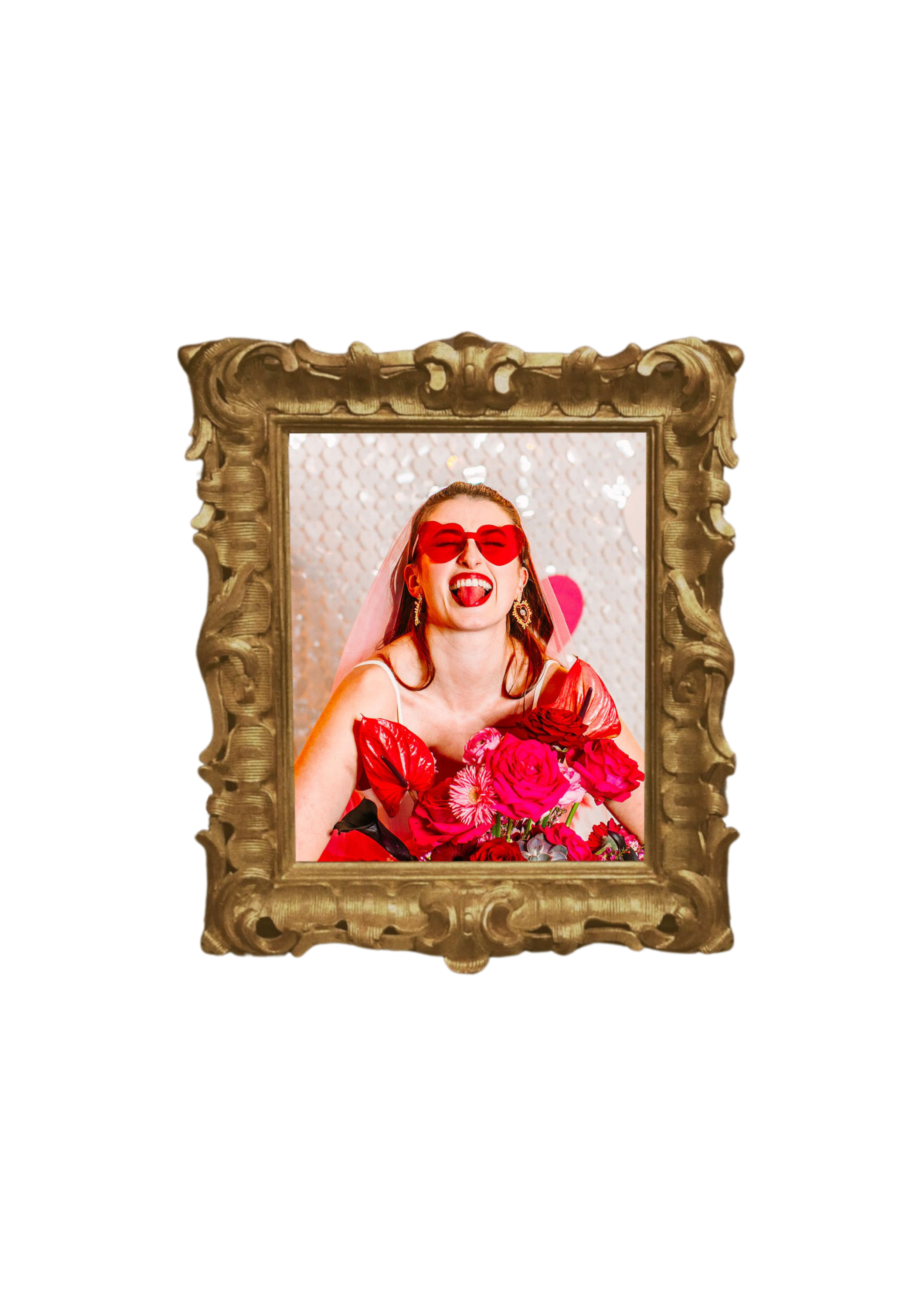 A woman with red hair wearing red sunglasses and a veil, holding a bouquet of pink and red roses, making a playful expression with her tongue out, framed in an ornate gold picture frame.