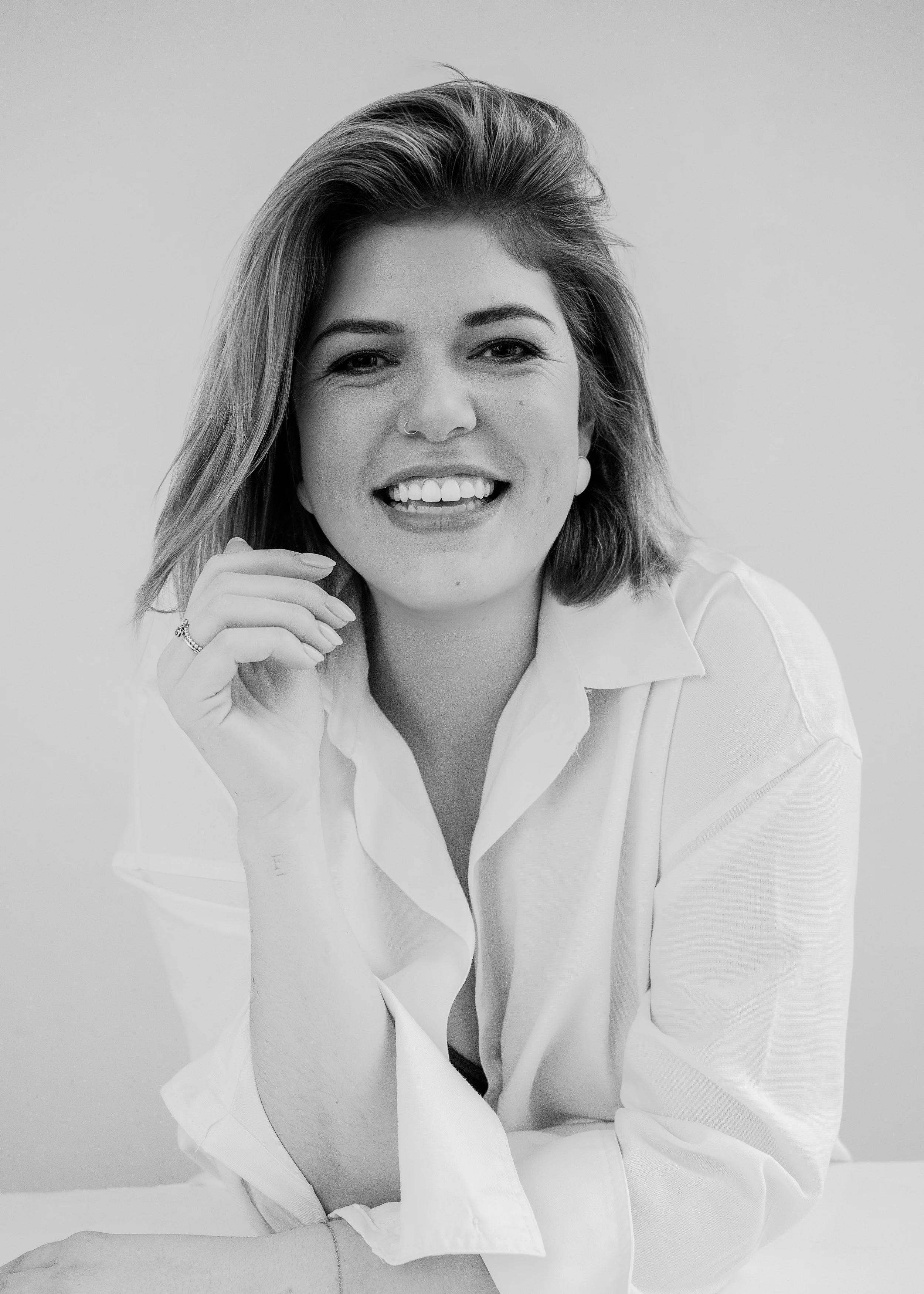 Portret van Elisa Vanooteghm van ZOOM Fotoatelier, lachend met een brede, warme glimlach. Ze is Studio Manager en het rustige hart van de studio.