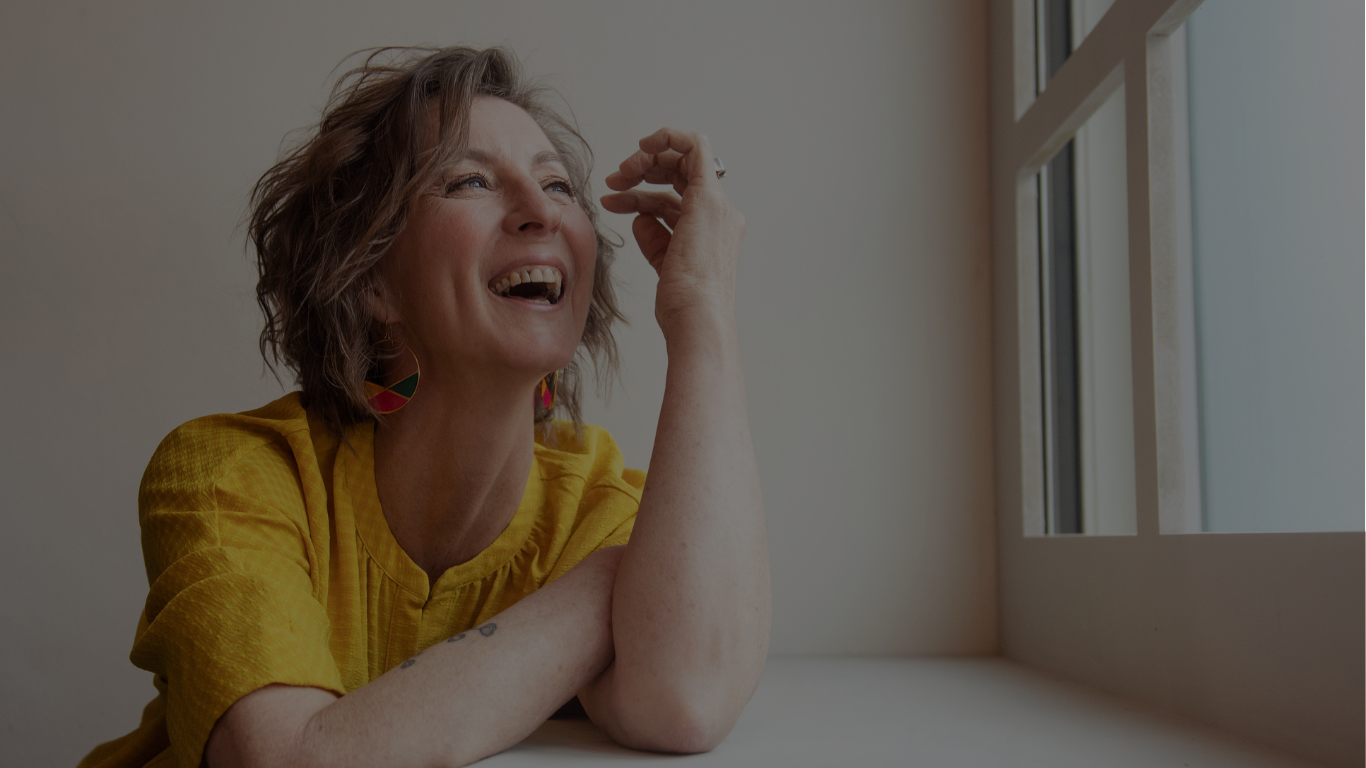 Een vrouw lacht bij het raam