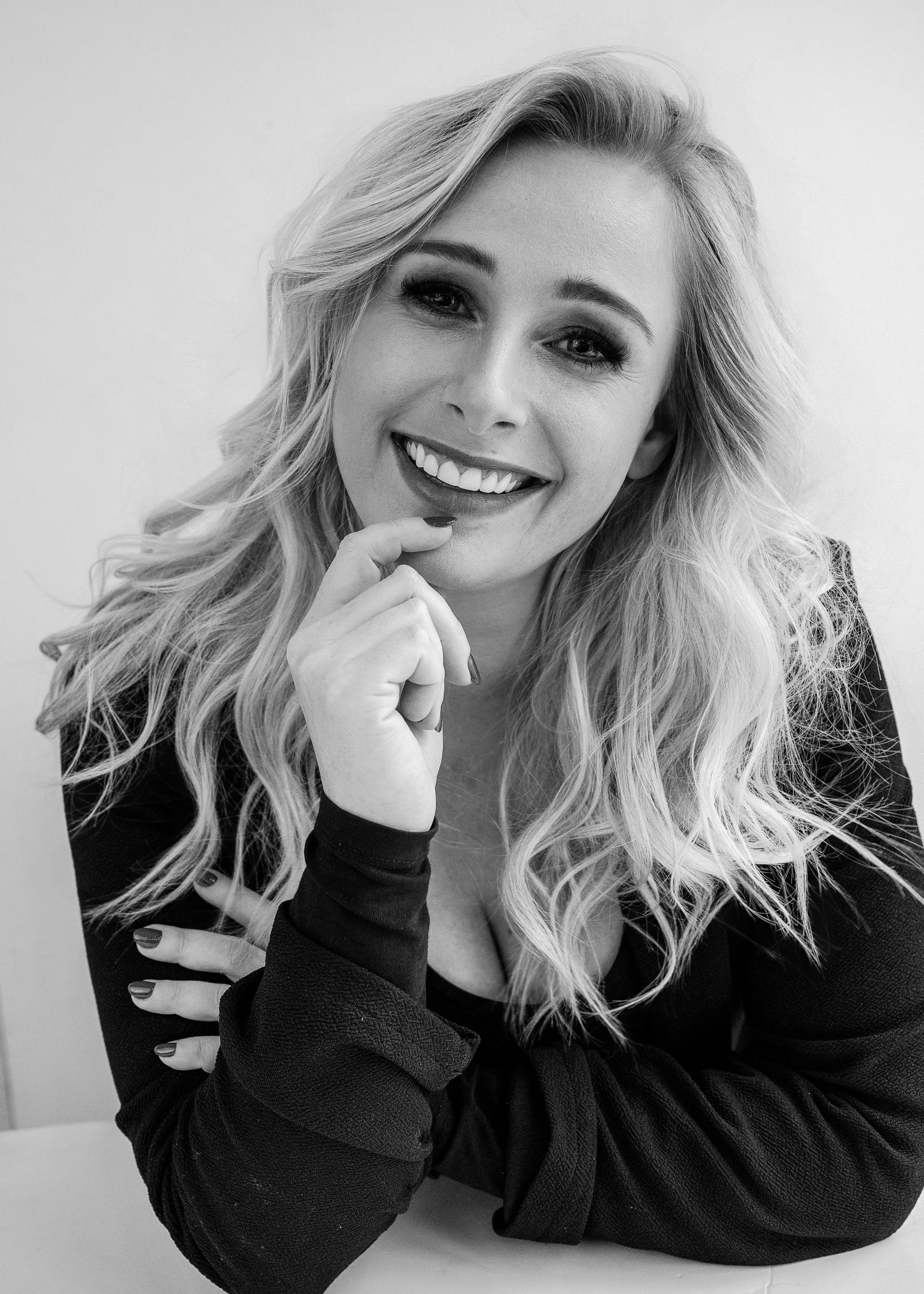 Portret van Julie van ZOOM Fotoatelier, met een open en warme glimlach. Ze is de stem aan de telefoon en begeleidt klanten tijdens hun Ontwerpsessie.