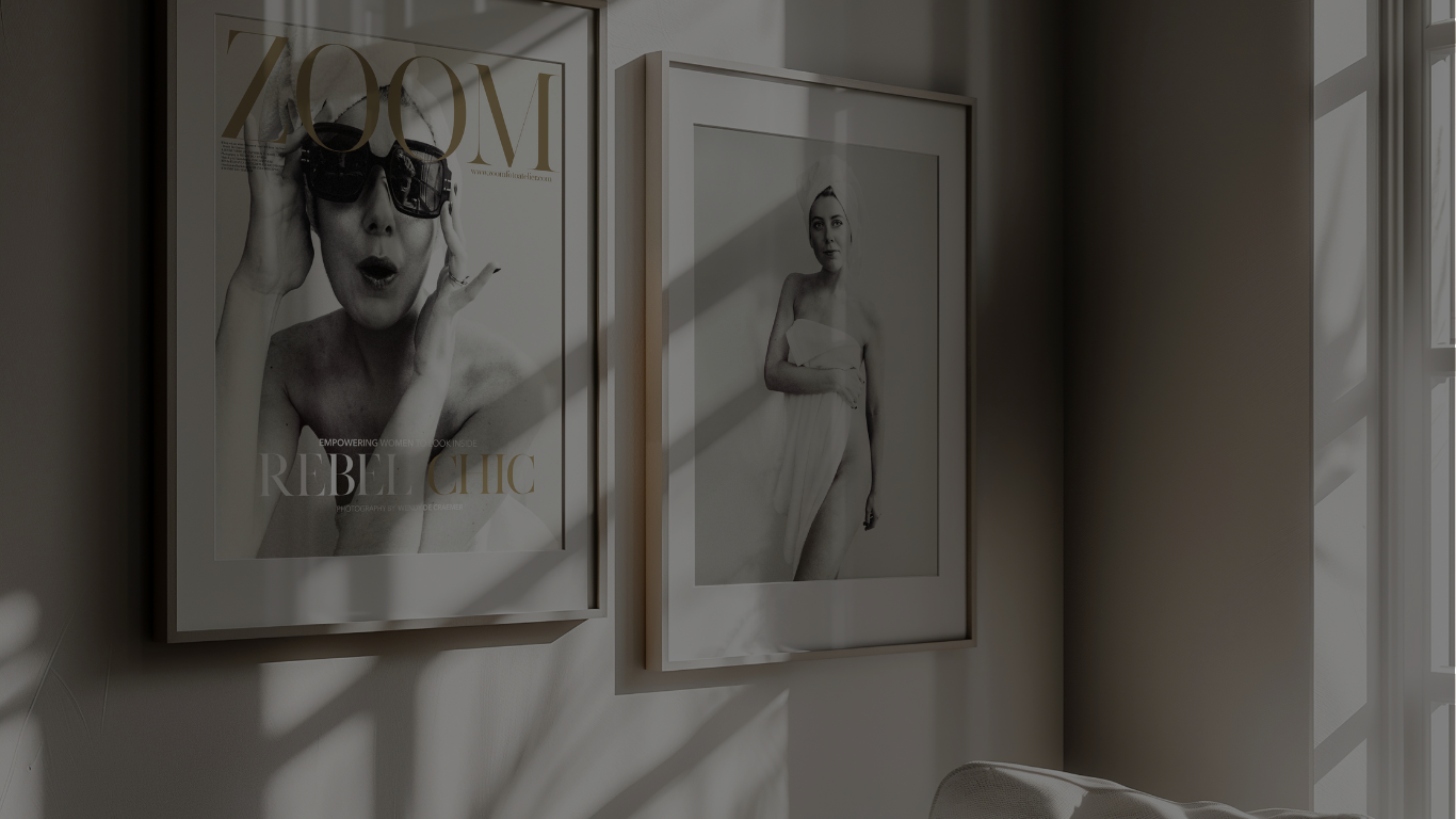 Lijstjes met ZOOM mode tijdschrift covers aan een muur, zacht licht valt door jaloezieën — een rustig, stijlvol sfeerbeeld.