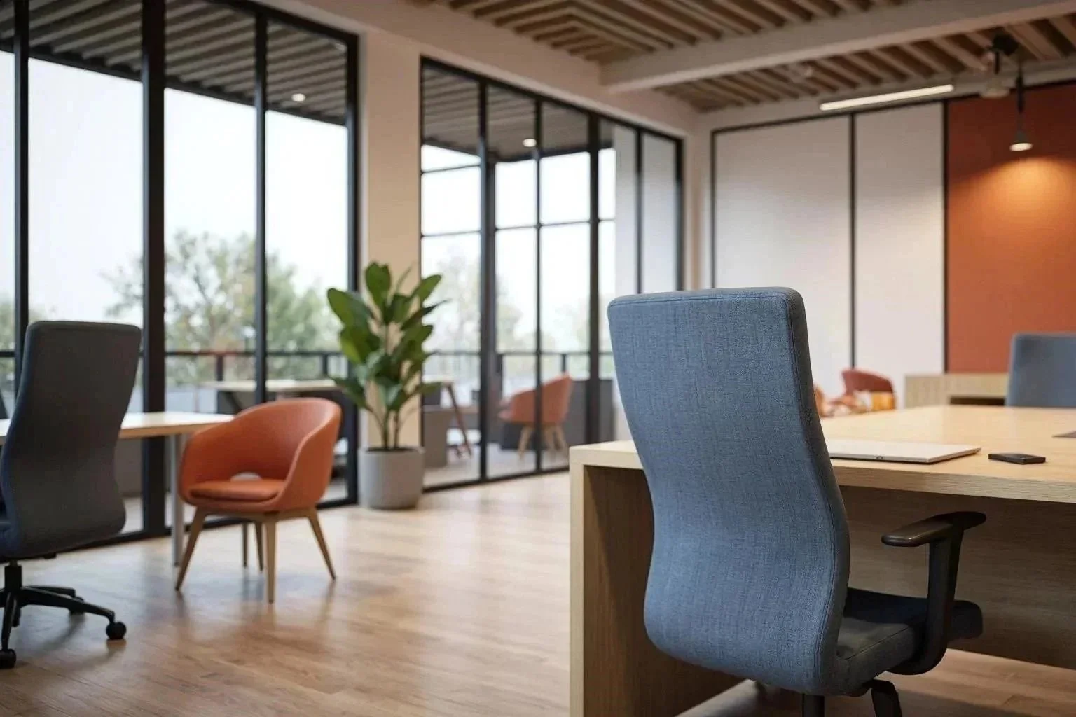 Modernes, möbliertes Büro mit großen Fenstern, Pflanzen, einem großen Tisch und verschiedenen Stühlen in warmen Farben.