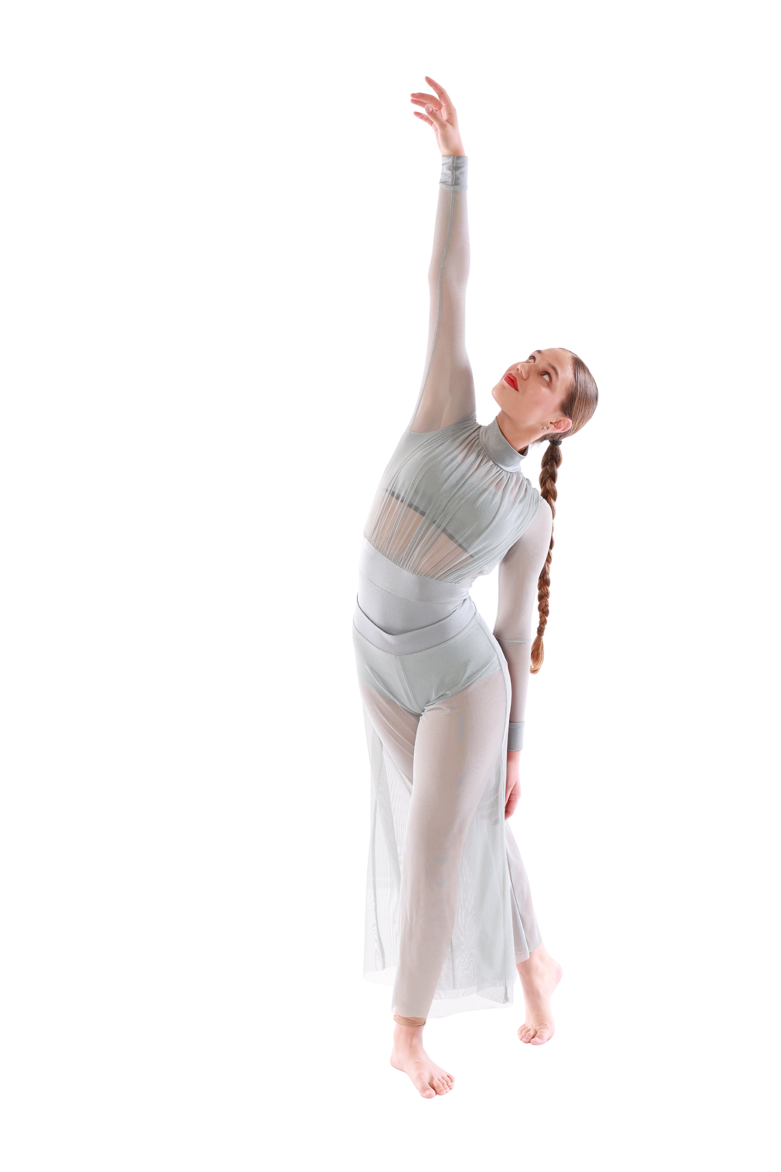 A woman in a modern, light-colored, semi-transparent dance costume performing a dance move with her left arm extended upward and her right arm down, standing on one leg, with her head tilted back and looking upward.