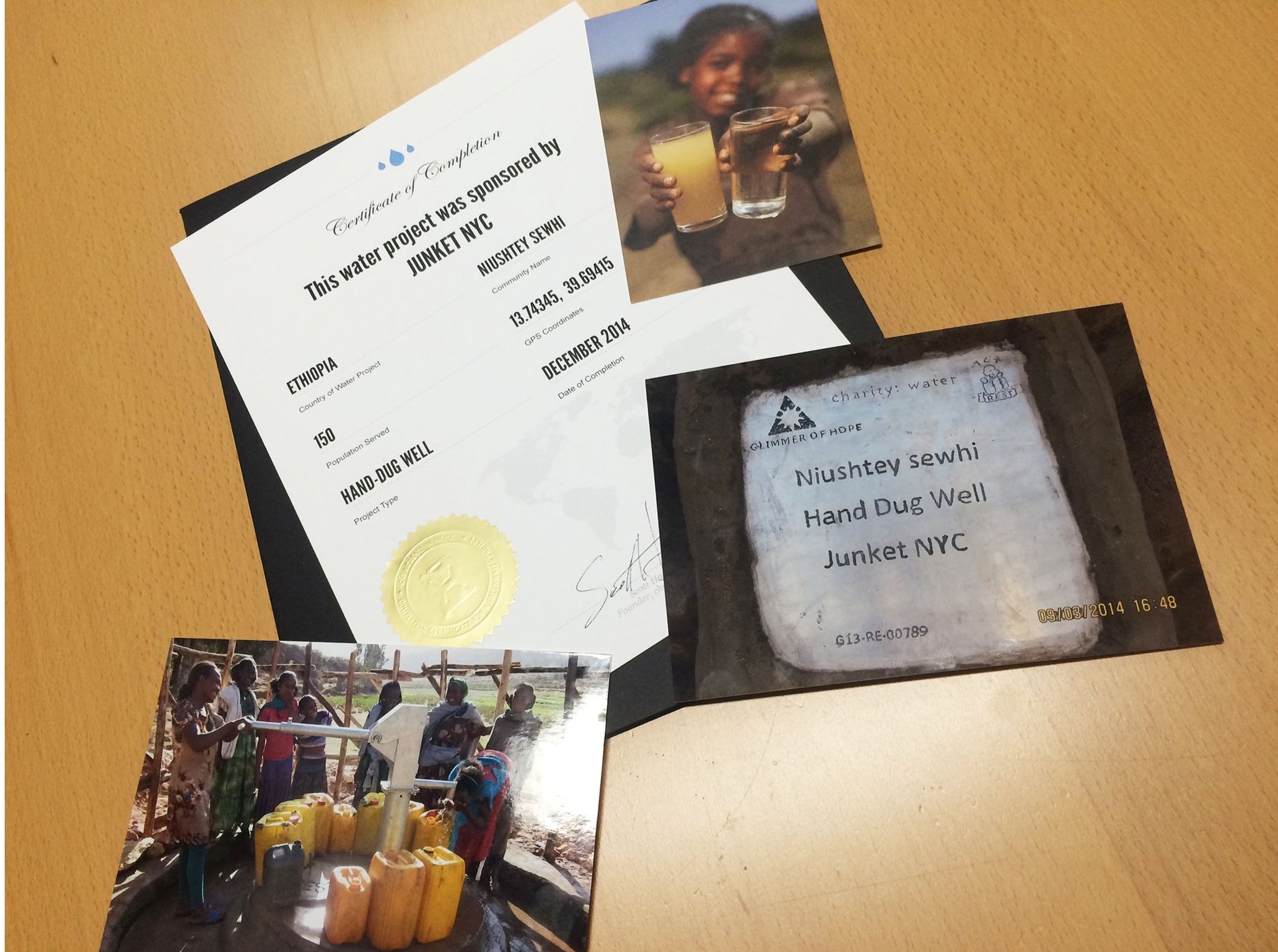 Certification, photos, and labels related to a water project in Ethiopia, including a certificate of completion, a photo of children holding glasses of water, and a photo of individuals collecting water from a well.