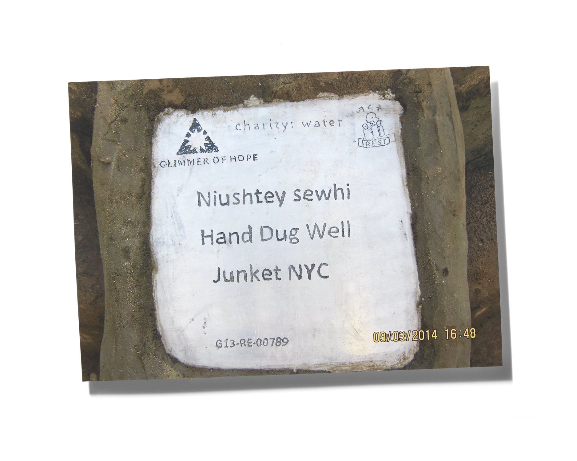 Sign with charity water logo and handwritten message: Niushtay sewhi, Hand Dug Well, Junket NYC, dated September 3, 2014.