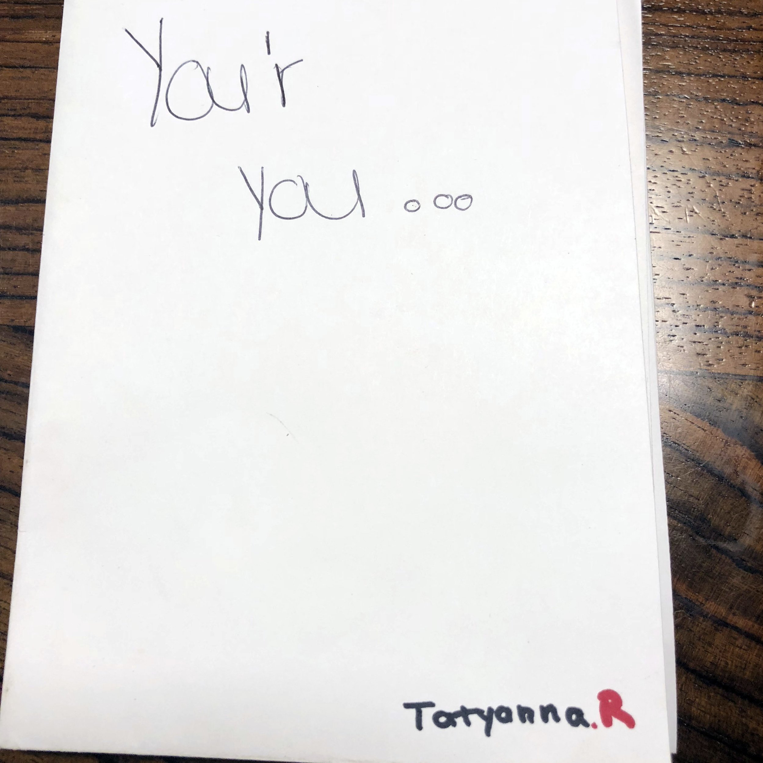 A white card with handwritten text saying "You're youoo" and the name "Taryanna.R" with a small red heart.