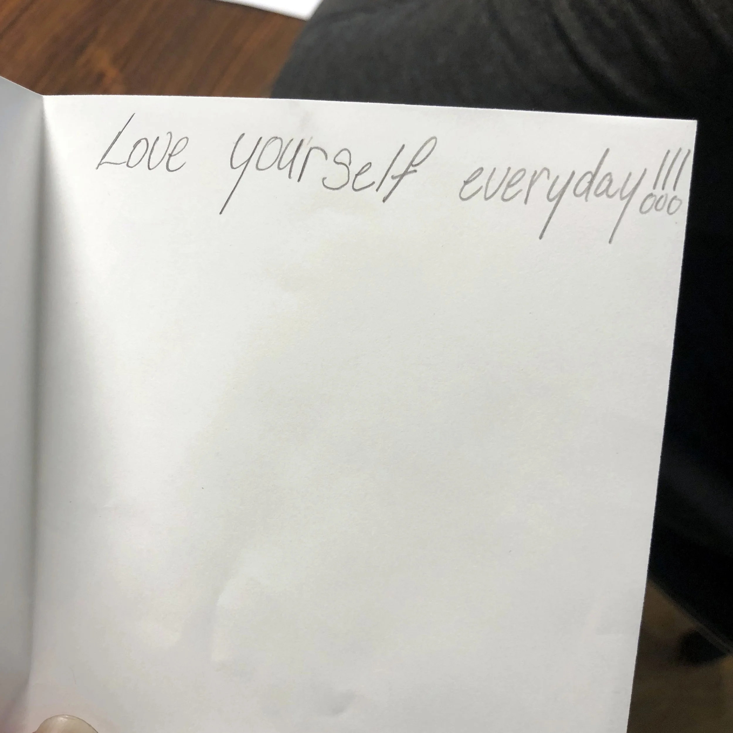A notebook page with the handwritten message 'Love yourself everyday!!!'