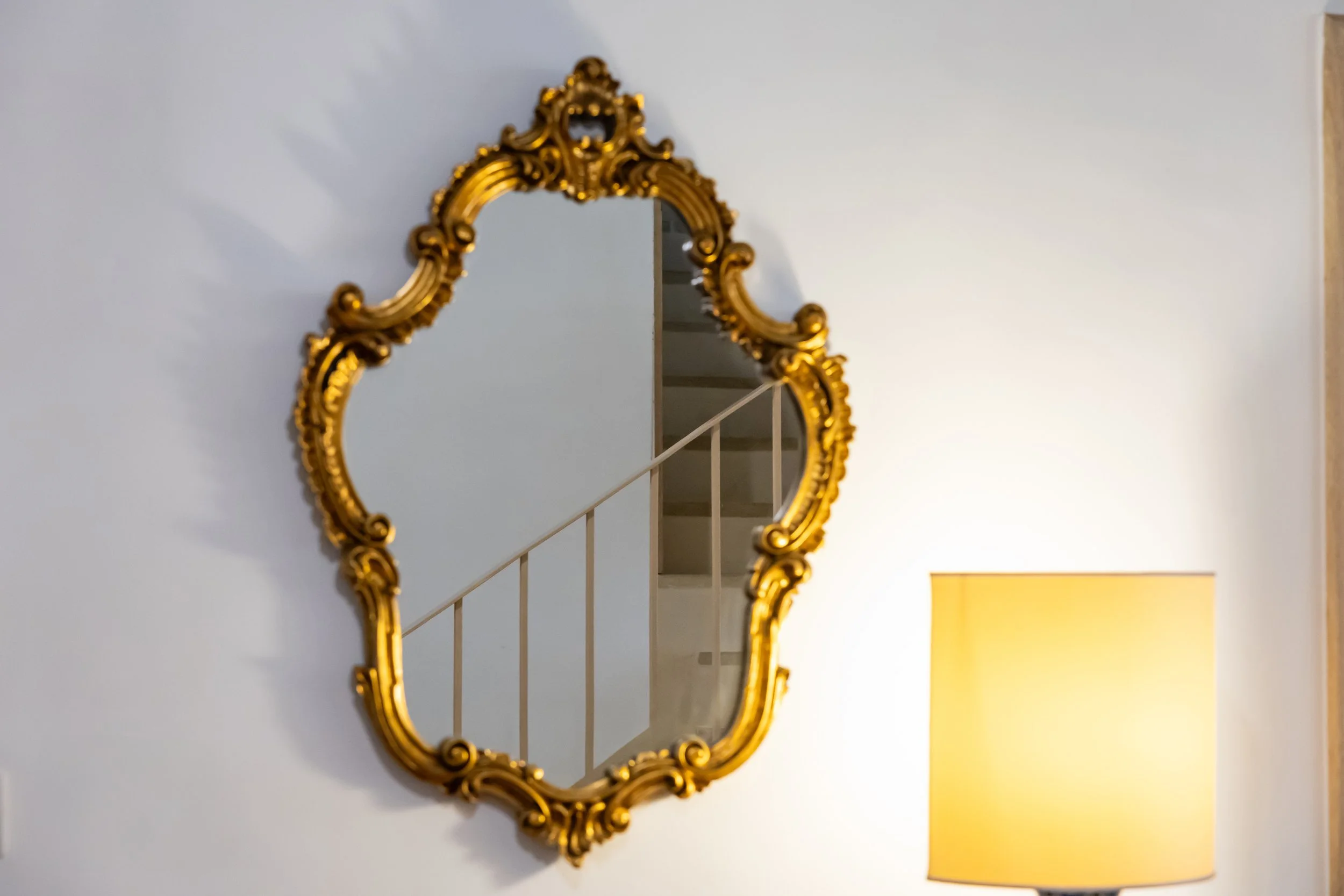 Decorative mirror at the entrance of Palazzo Dolce Vita, reflecting the staircase and creating a warm first impression.