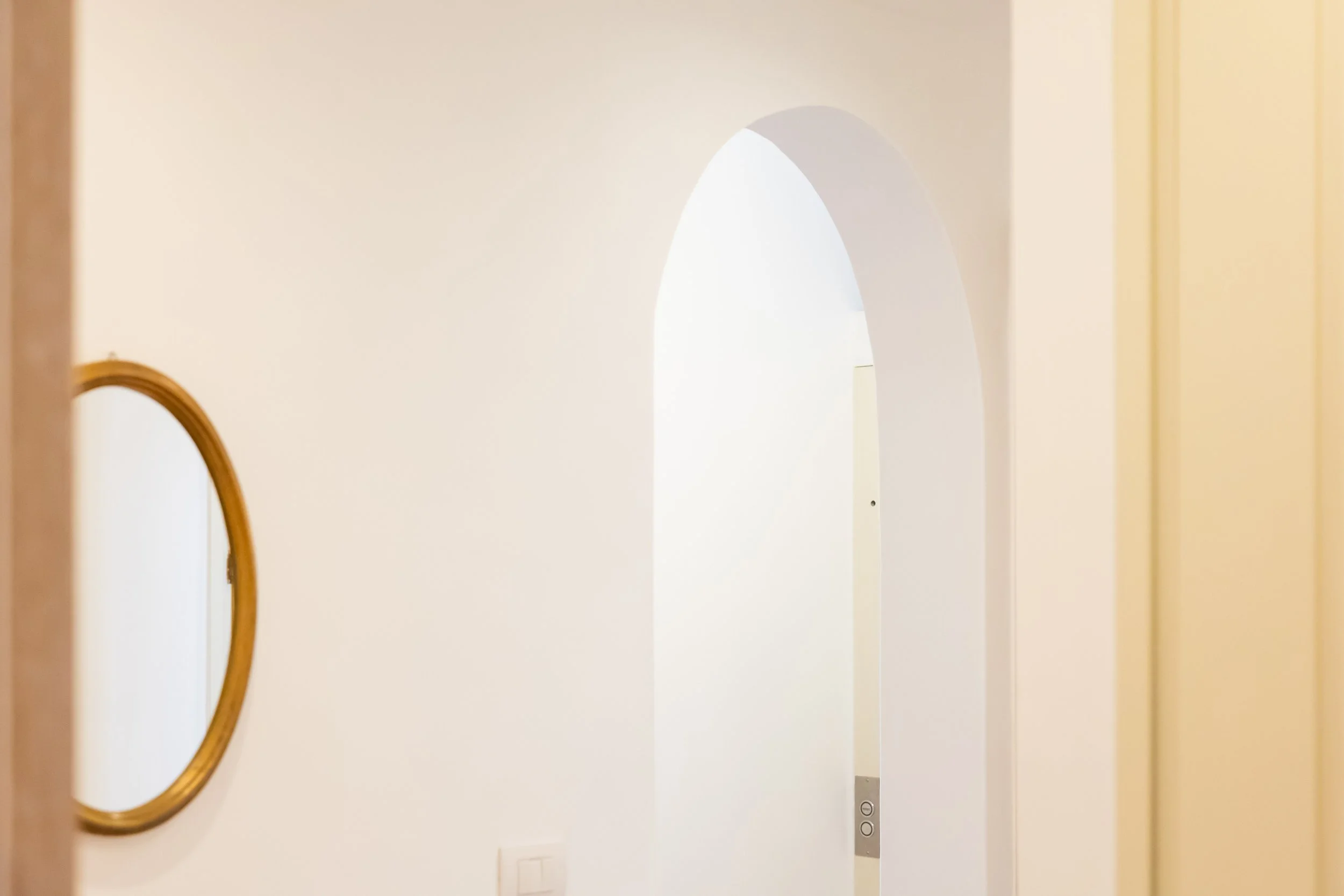 Interior hallway at Palazzo Dolce Vita, with a rounded archway leading to one of the bedrooms.