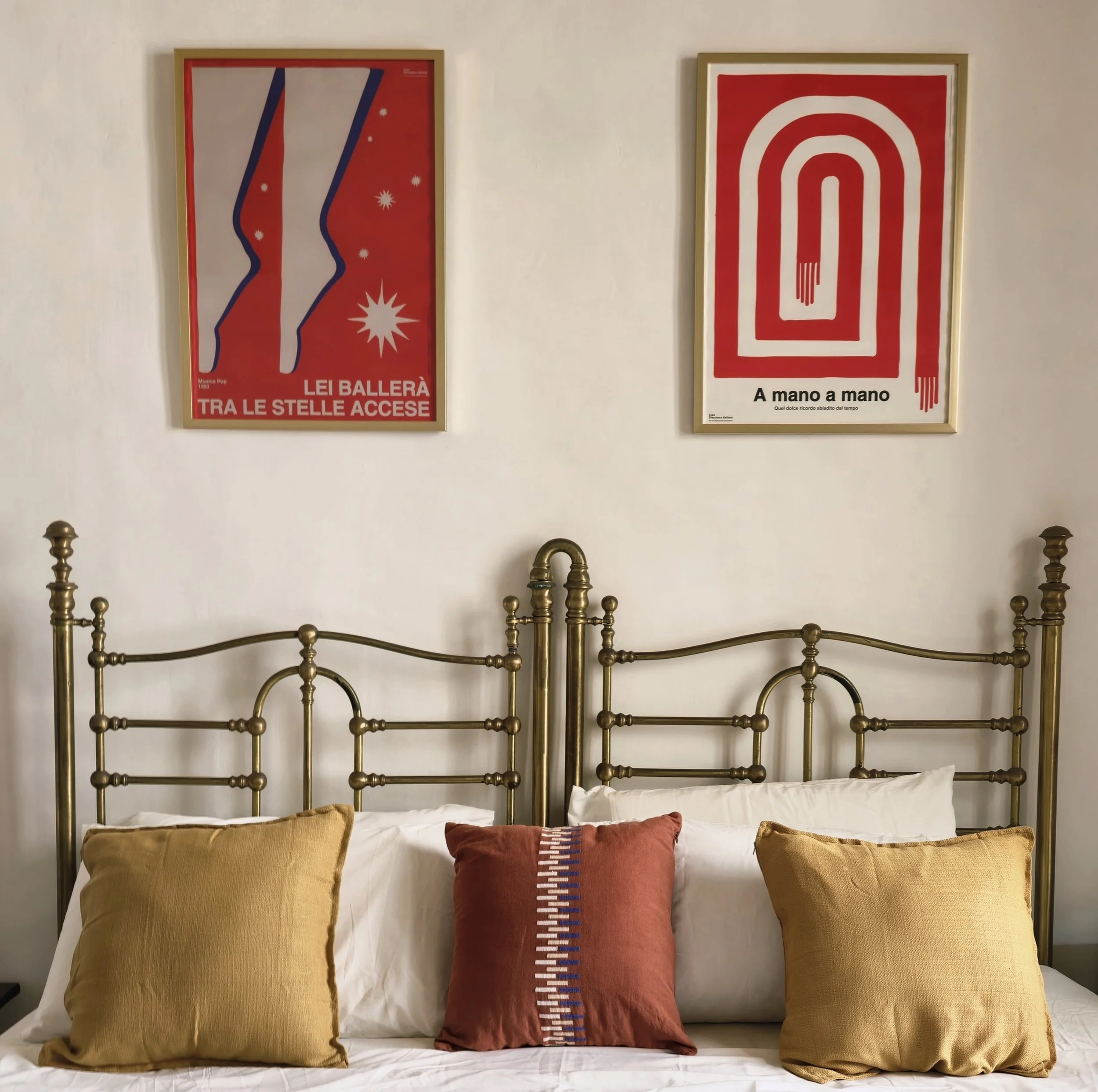 Master bedroom at Palazzo Dolce Vita with ensuite bathroom, styled with a gold metal bed, warm tones and contemporary art.