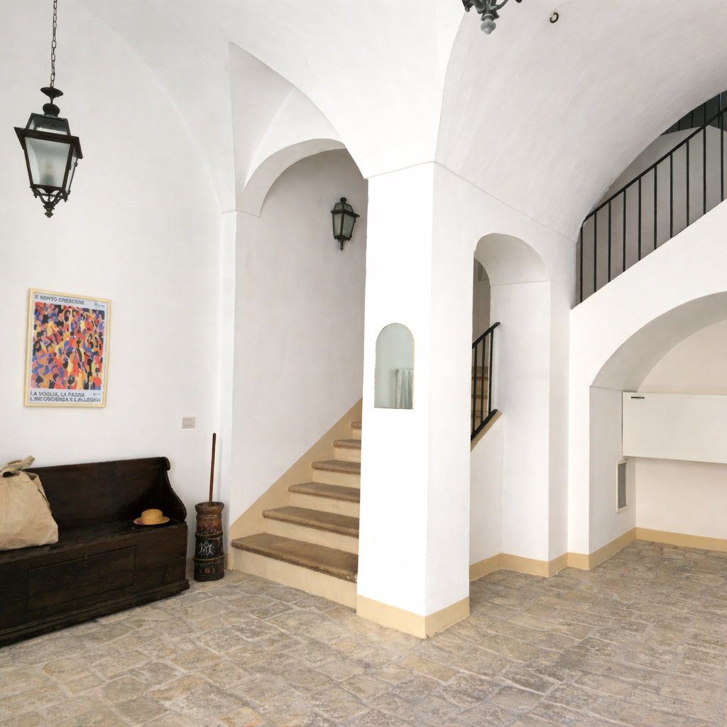 Entrance courtyard at Palazzo Dolce Vita, with stone flooring and a staircase leading to the main entrance of the house.