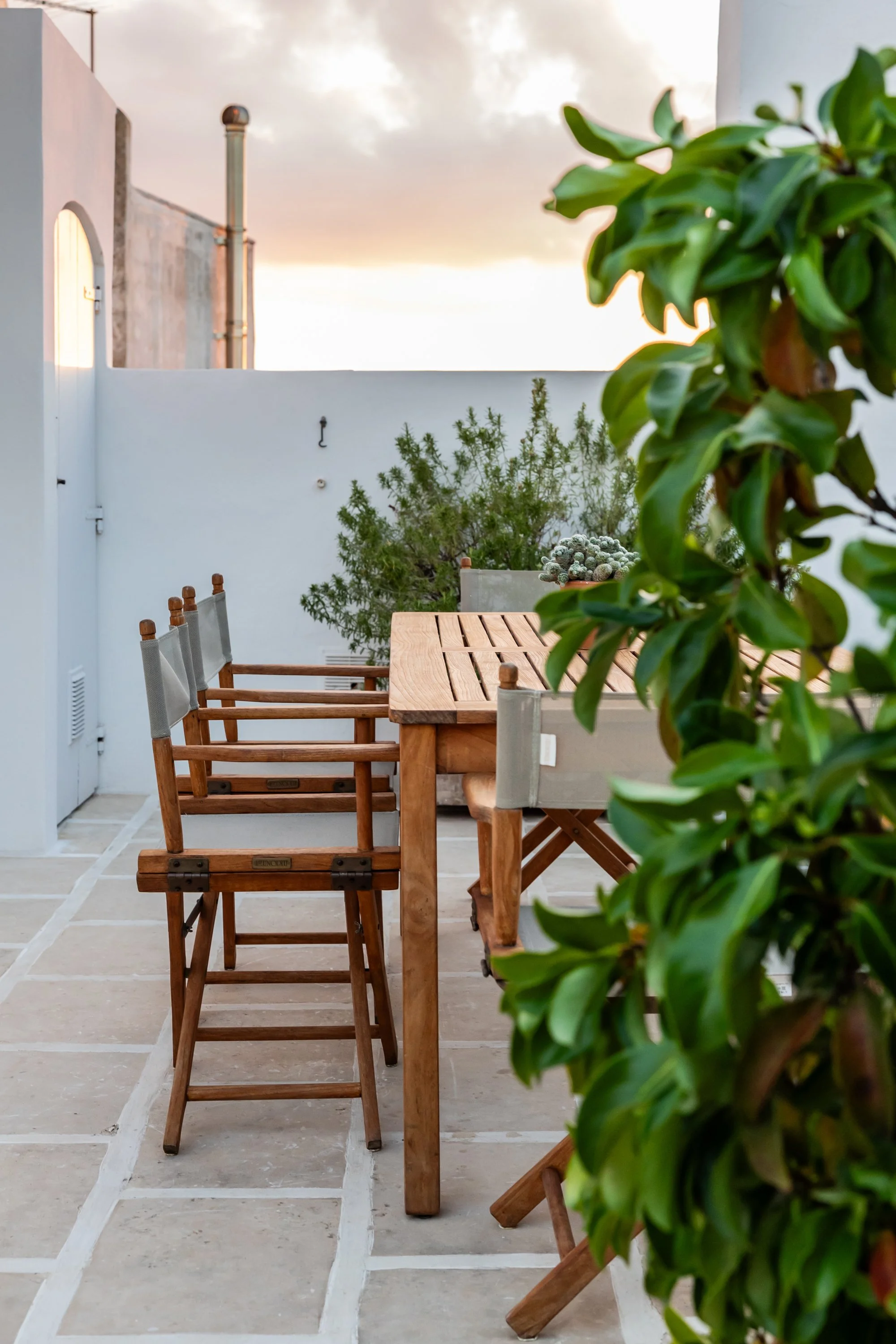 Outdoor kitchen at Palazzo Dolce Vita at sunset, with a teak dining table for six and a relaxed open-air atmosphere.