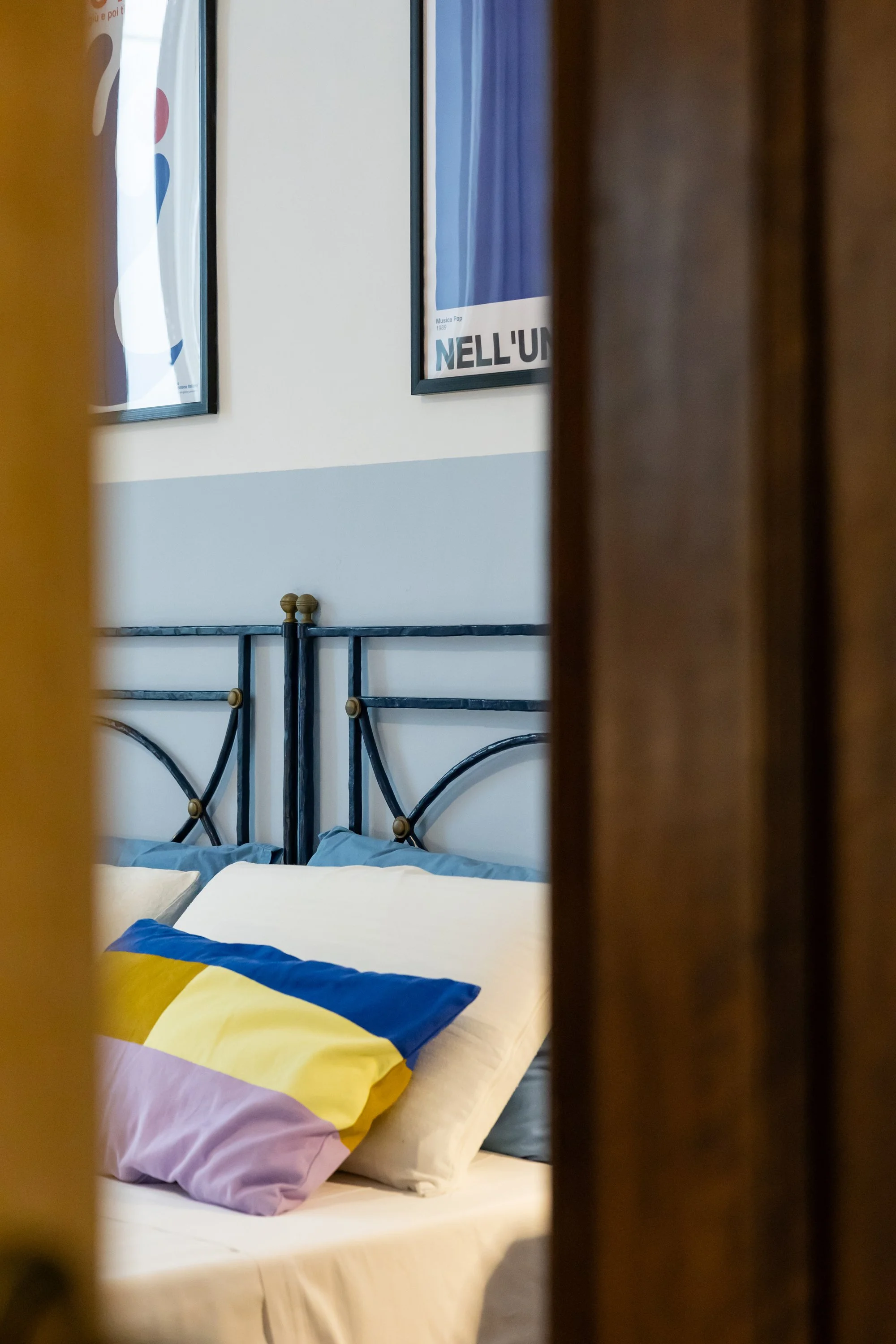 Double bedroom at Palazzo Dolce Vita in Gallipoli Old Town, styled bed with decorative pillows and artwork.