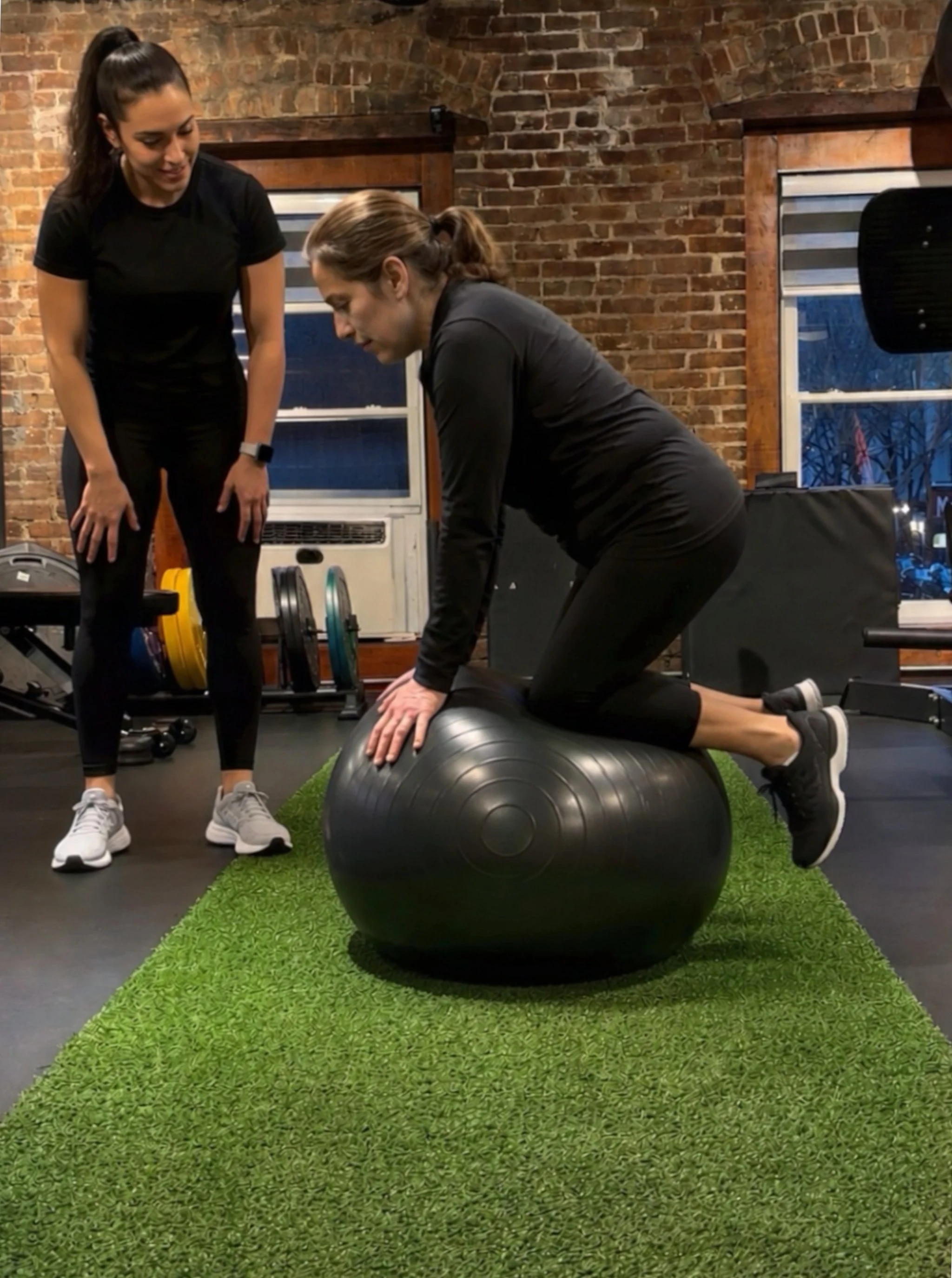 Client on Ball with Trainer.jpg