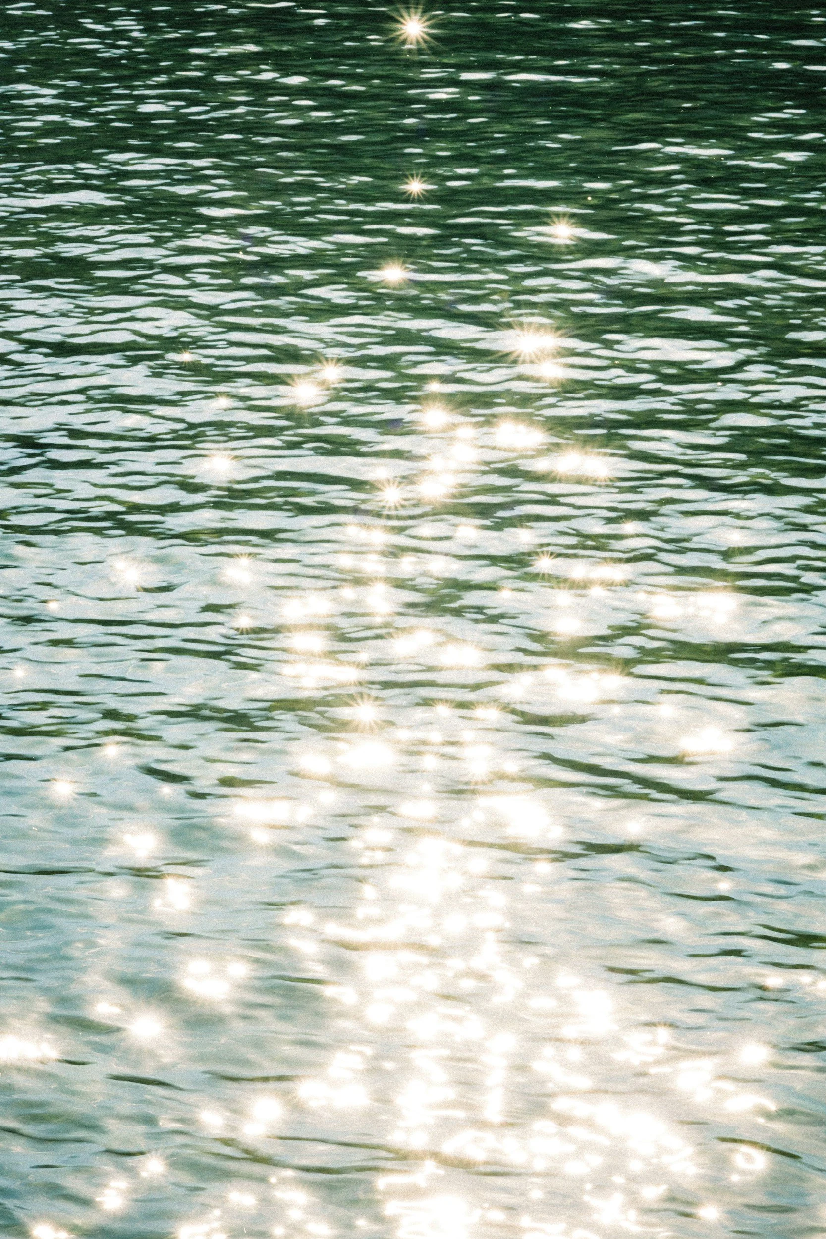 Sunlight sparkling on the surface of a body of water.