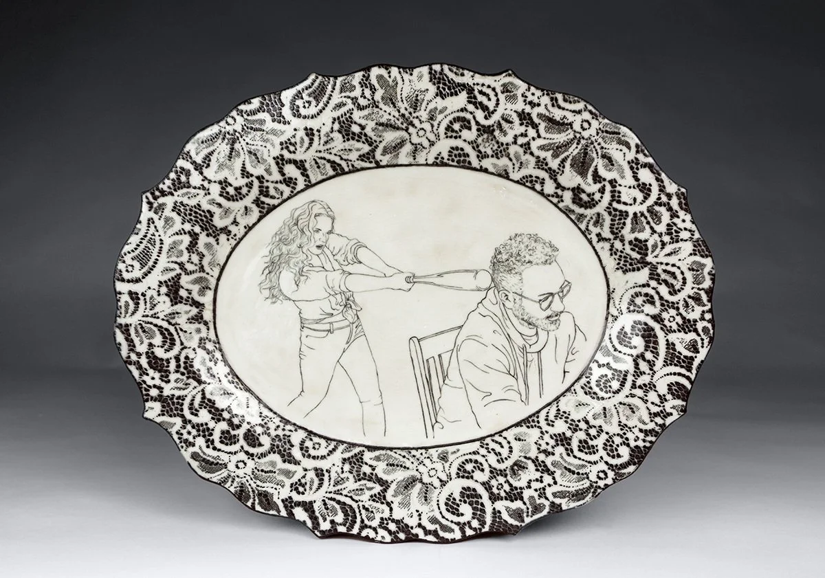 Decorative porcelain plate with a black lace pattern border and a monochrome illustration of a woman swinging a baseball bat a a man who is seated and wearing glasses.